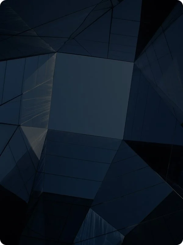 Abstract view of a glass building's interior with mirrored panels and geometric patterns.