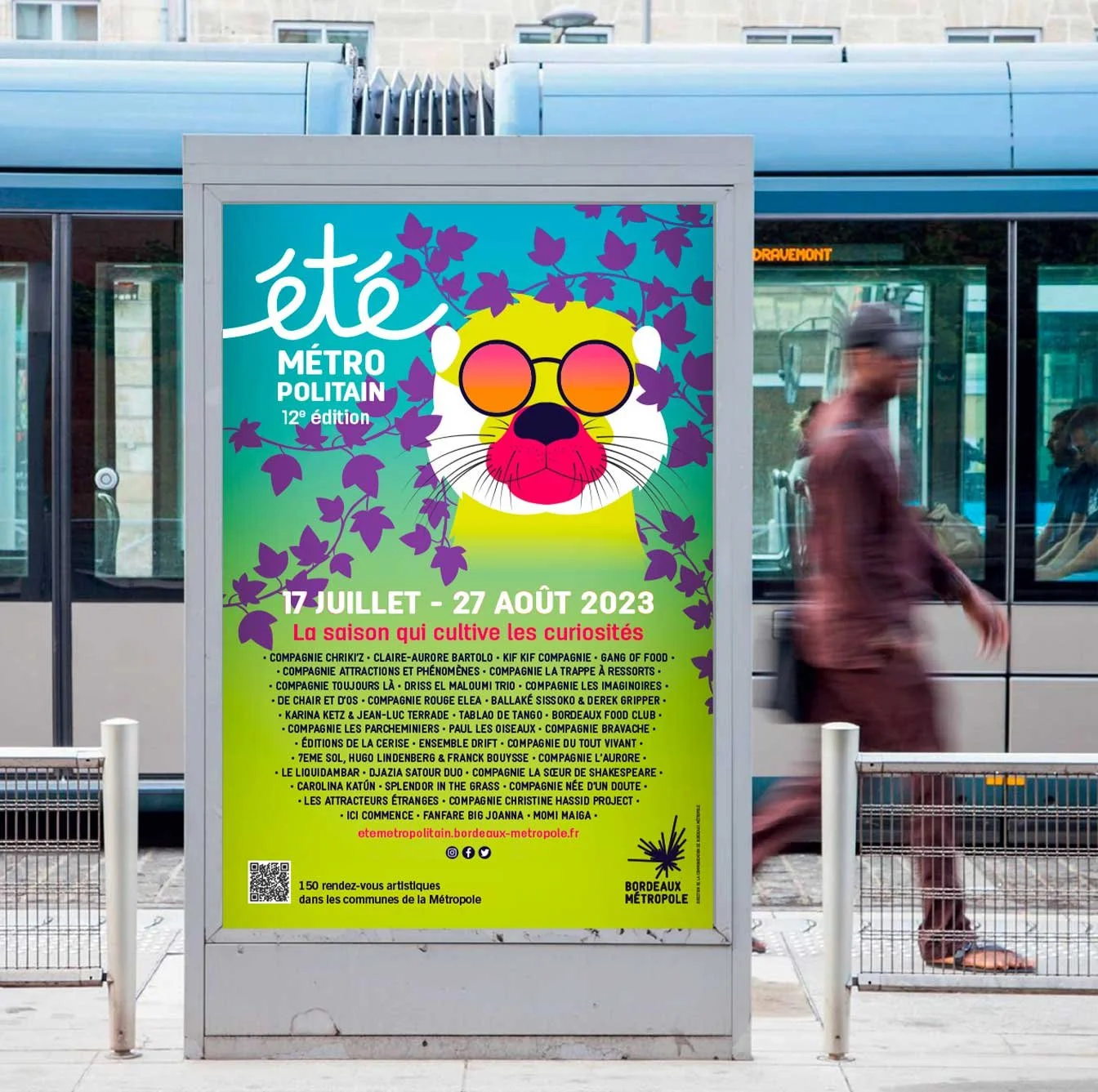 Affiche promotionnelle pour l'événement 'été Métro Politain', 12e édition, du 17 juillet au 27 août 2023, avec un lion portant des lunettes roses, des feuilles violettes en arrière-plan, et une liste de participants et d'activités en bas.