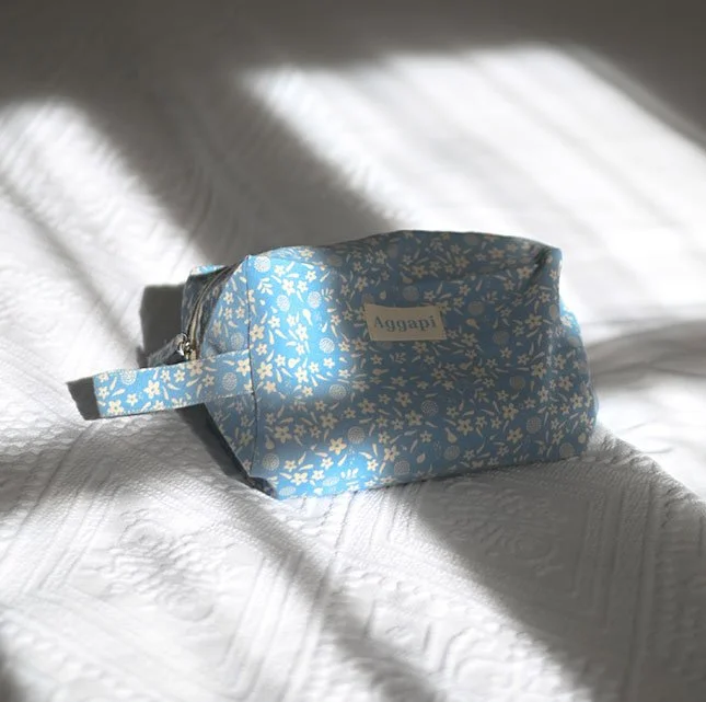 Déclinaison de l'identité visuelle Aggapi sur une trousse textile.