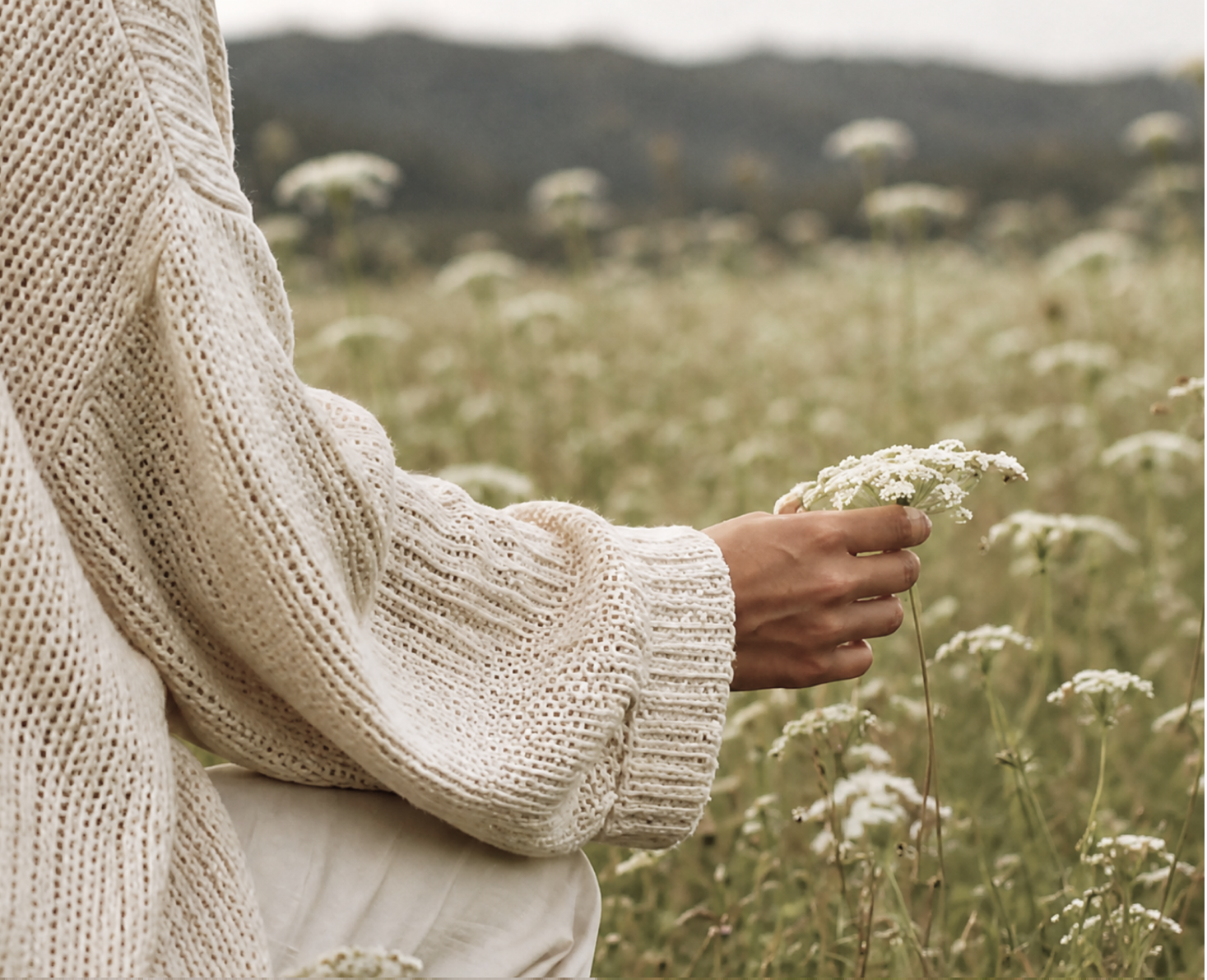 Woman standing freely in a wildflower meadow, symbolising transformation through mindset coaching in Dubai