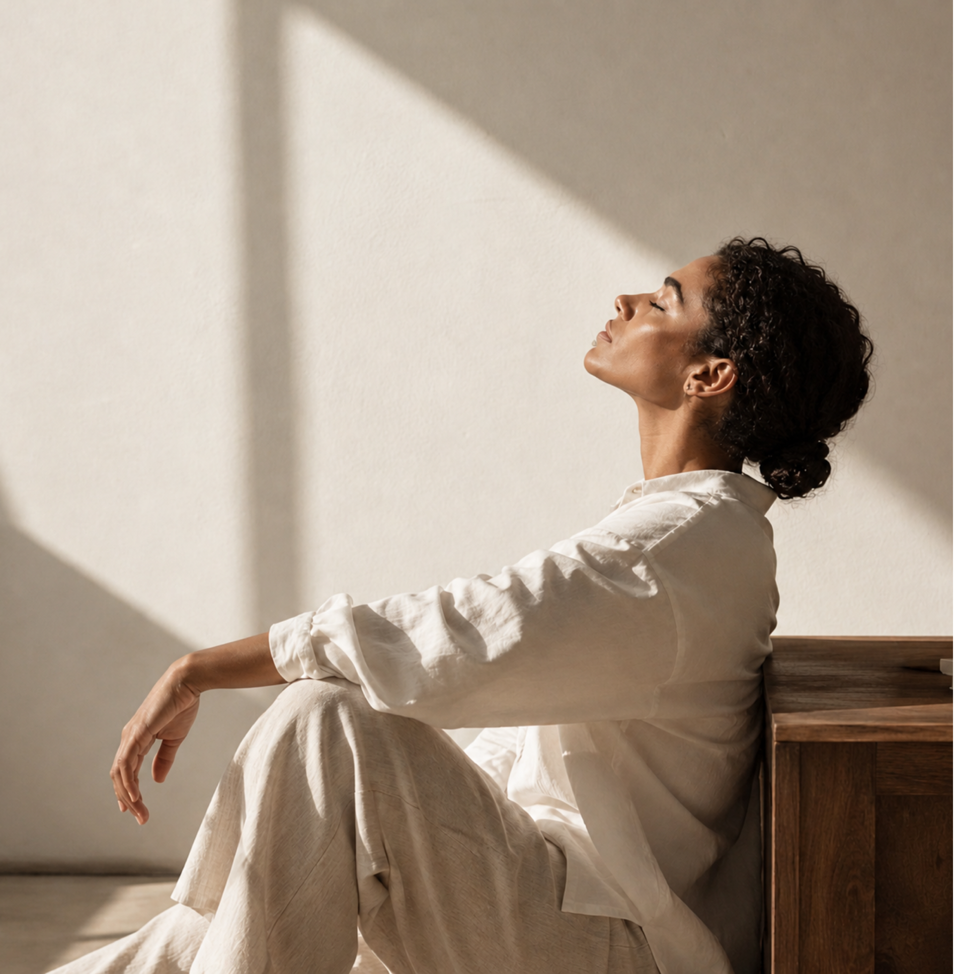 Woman resting peacefully in warm sunlight, representing calm and emotional healing through hypnotherapy in Dubai