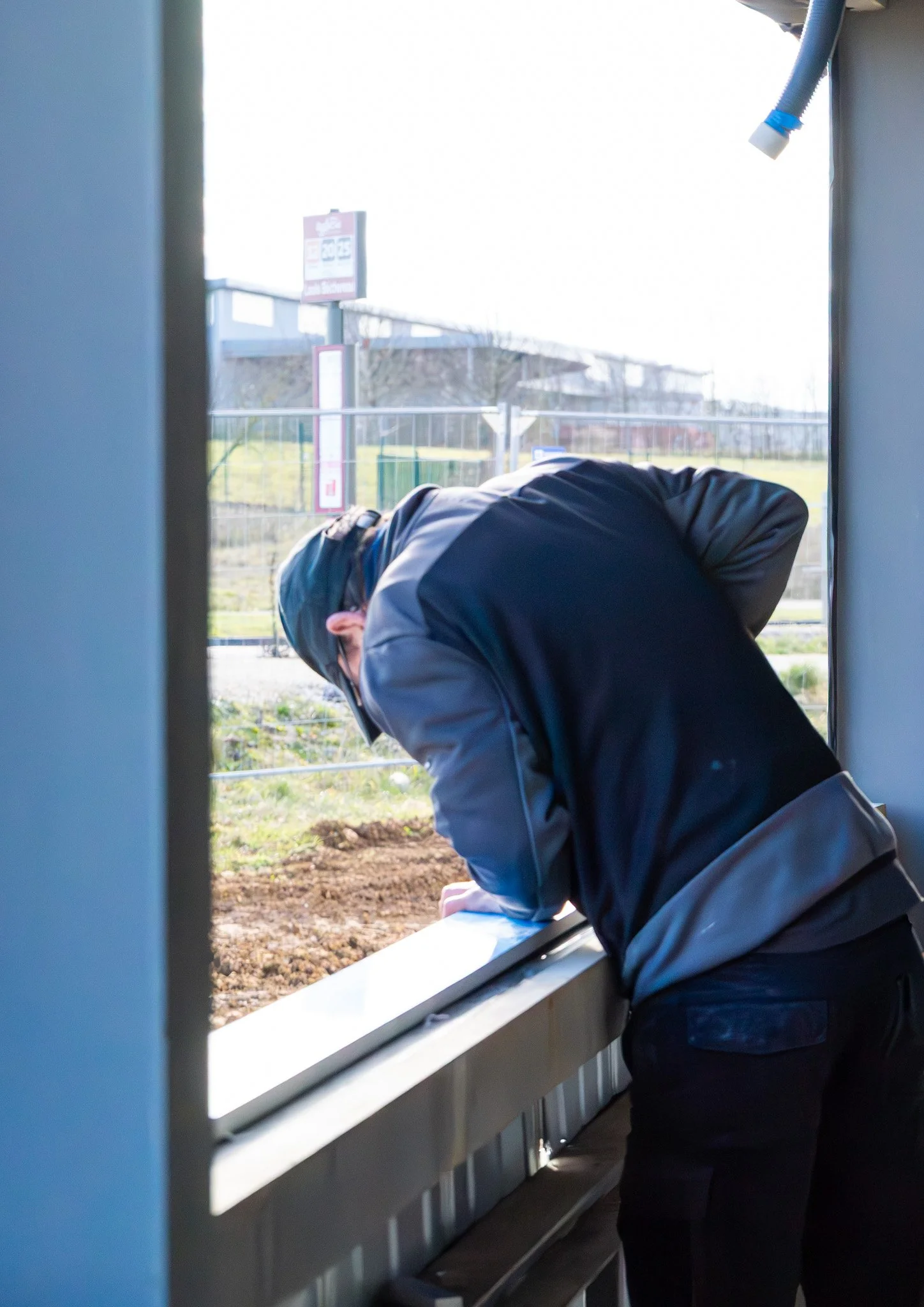 Une personne fixant une menuiserie en aluminium