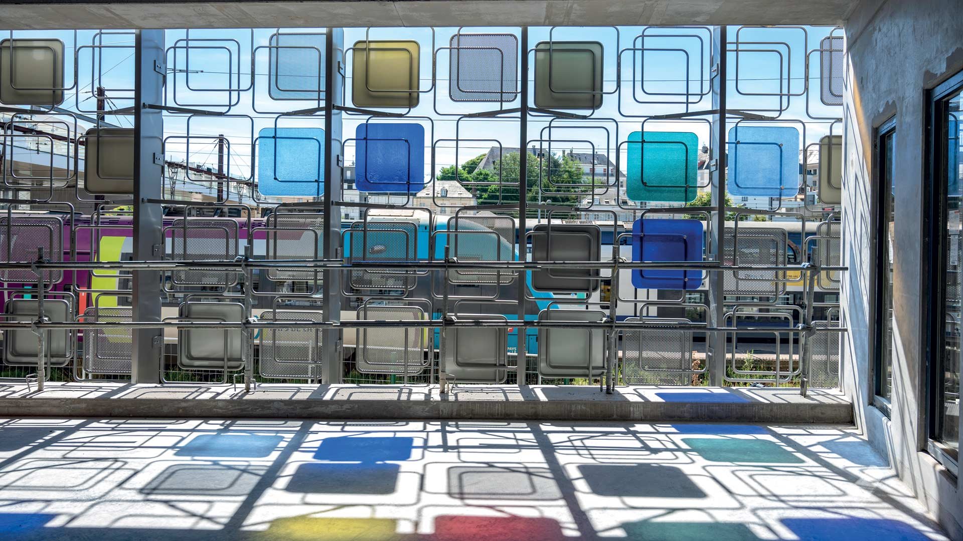 Vues d'une structure en métal avec des motifs de carrés de verre colorés