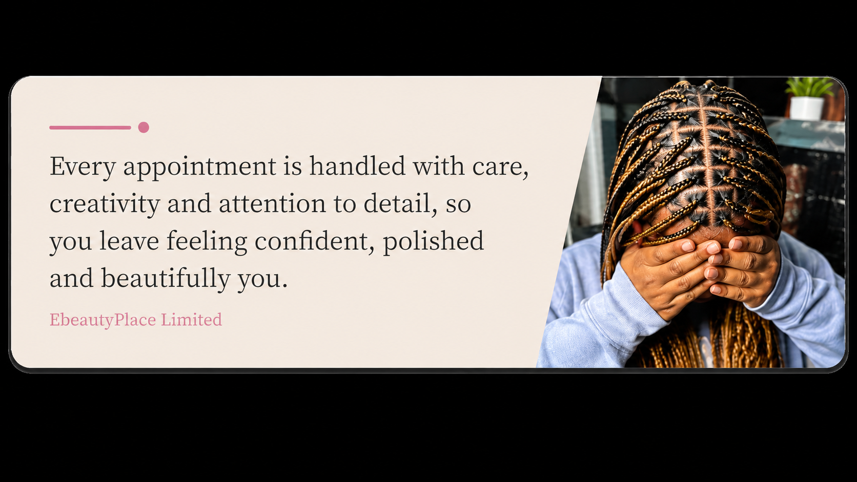 A person with braided hair covering their face with their hands, sitting in a salon or beauty studio.