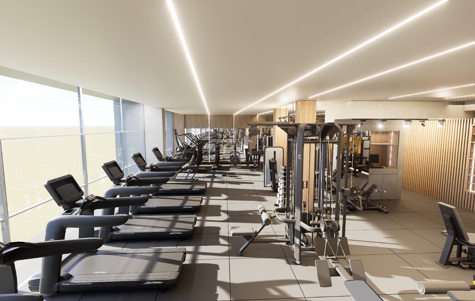 Academia moderna com equipamentos de cardio, musculação e peso, iluminação de fita no teto, grande janelas de vidro e decoração em tom de madeira, vista de longe.