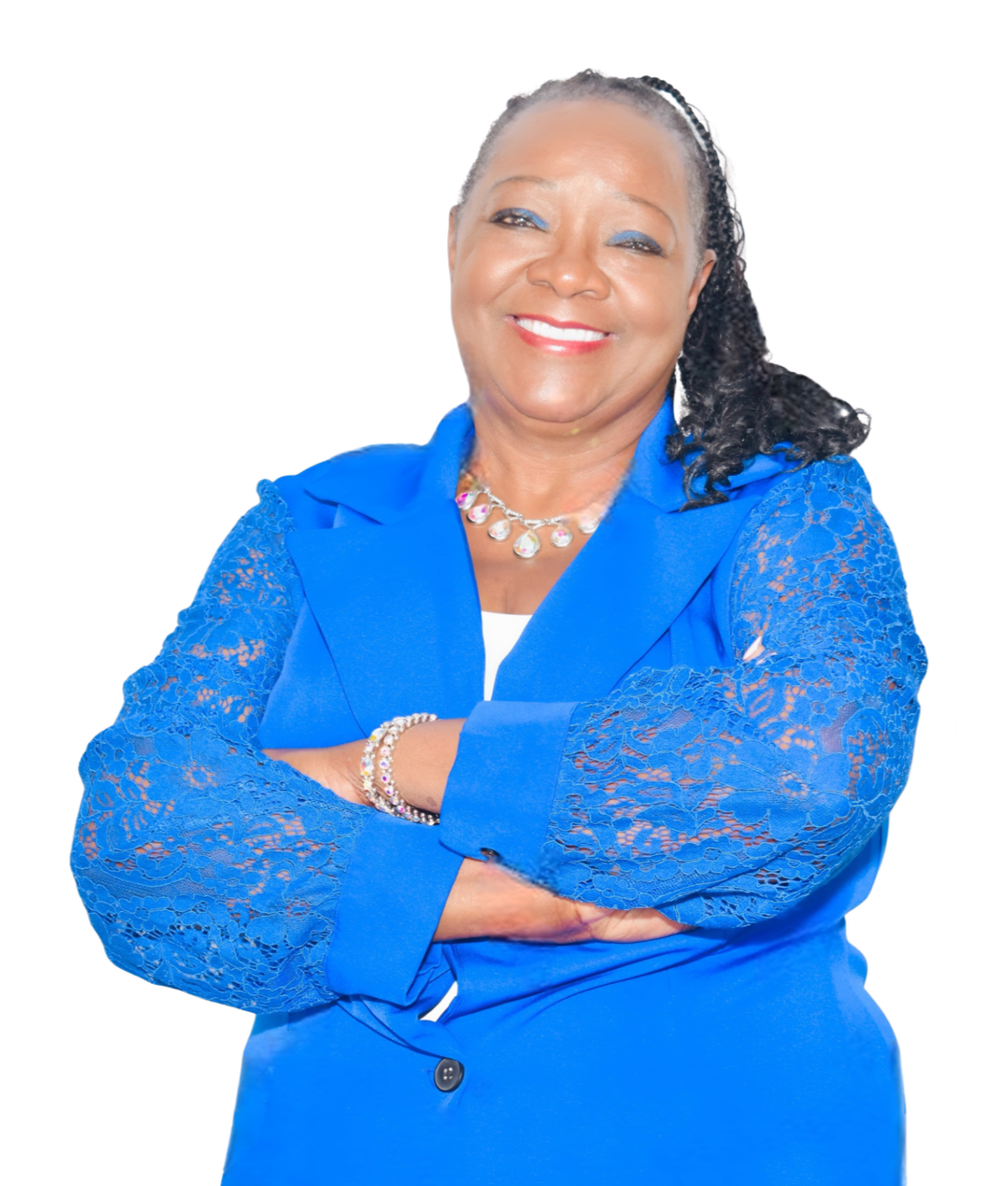 A smiling African American woman with crossed arms, wearing a bright blue blazer with lace sleeves, and accessorized with a necklace and bracelets. She has curly hair and is looking confidently at the camera.