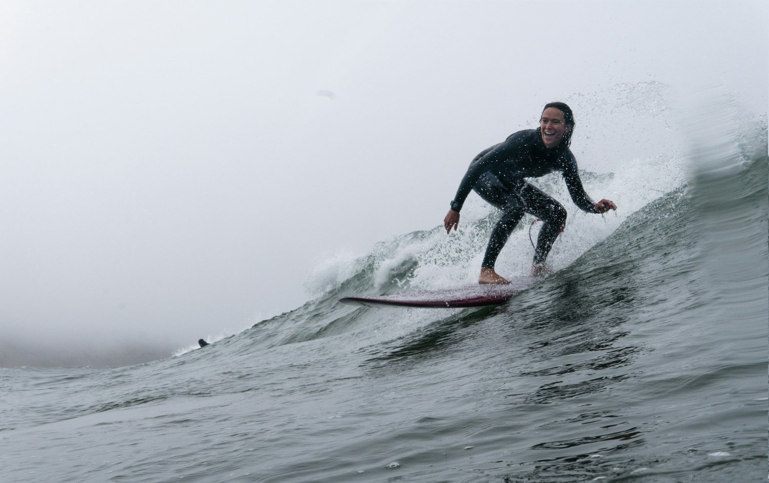 A surfer carving across the face of a wave