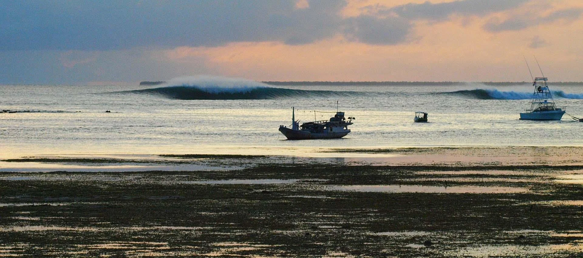 The Bommie surf break off Nembrala, Rote Island, with boats anchored offshore