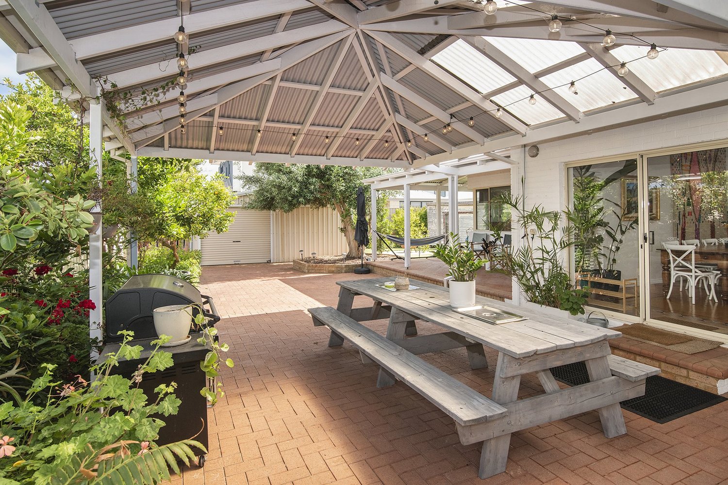 Covered patio with a long outdoor dining table
