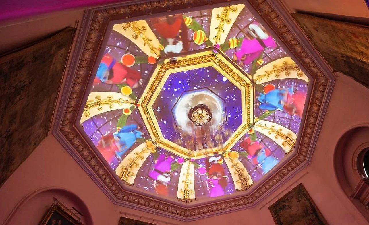 Decorated ceiling with colorful lights, carousel figures, and a starry sky background.