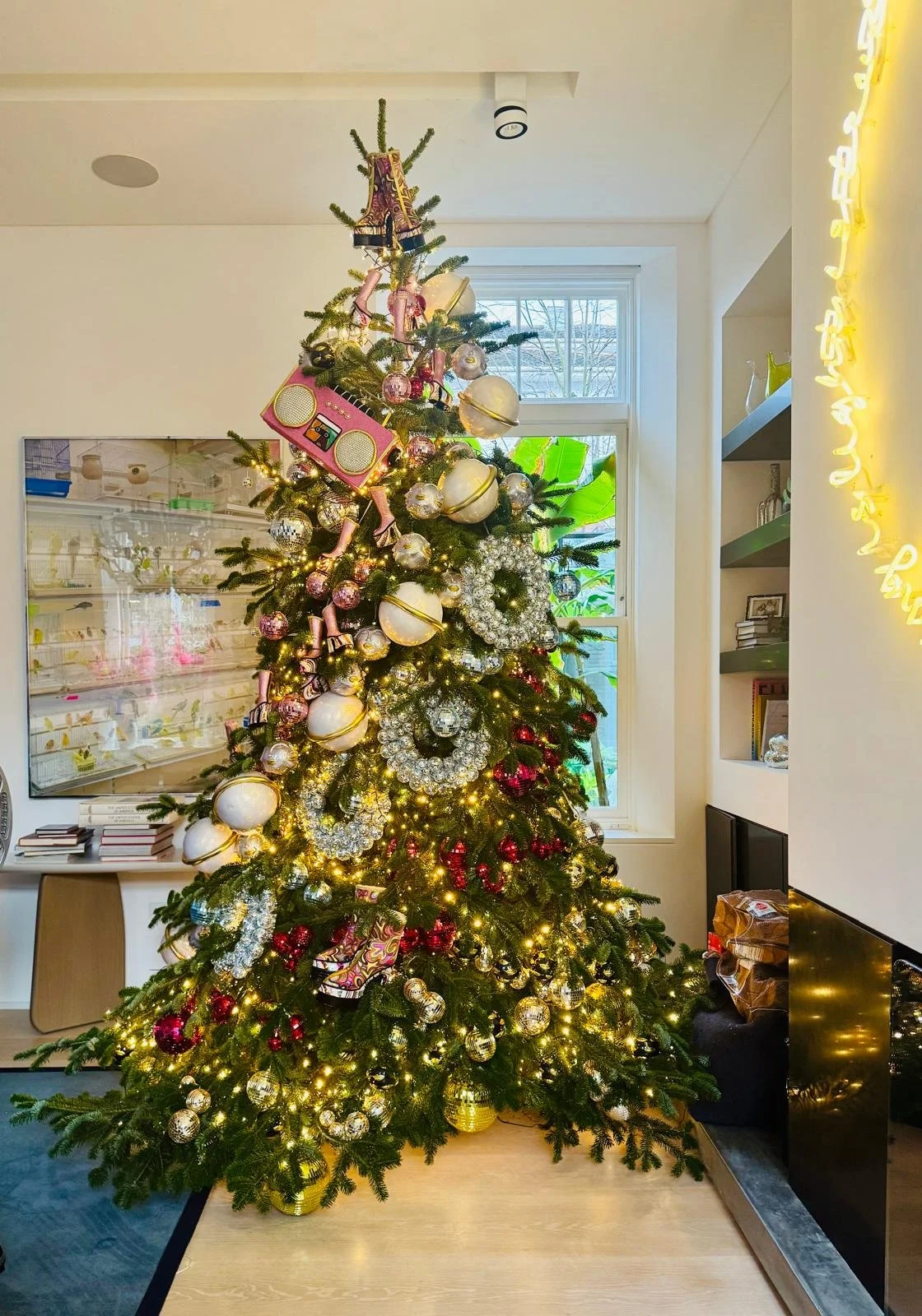 Decorated Christmas tree with ornaments and lights in a living room.