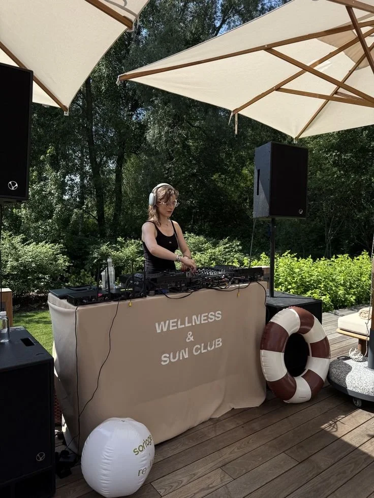 DJ set in green space with leaves, trees