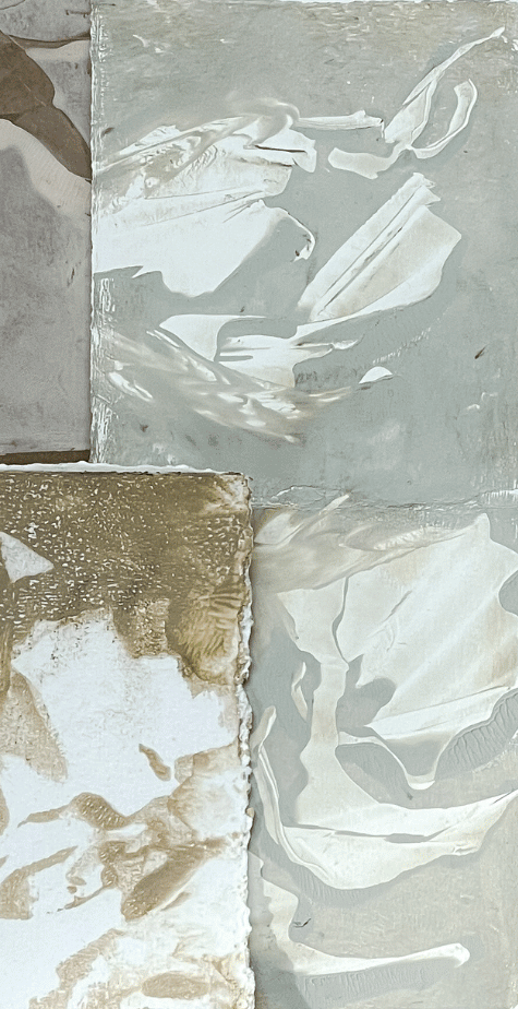 Close-up of a reflective metallic sculpture and a textured stone surface.