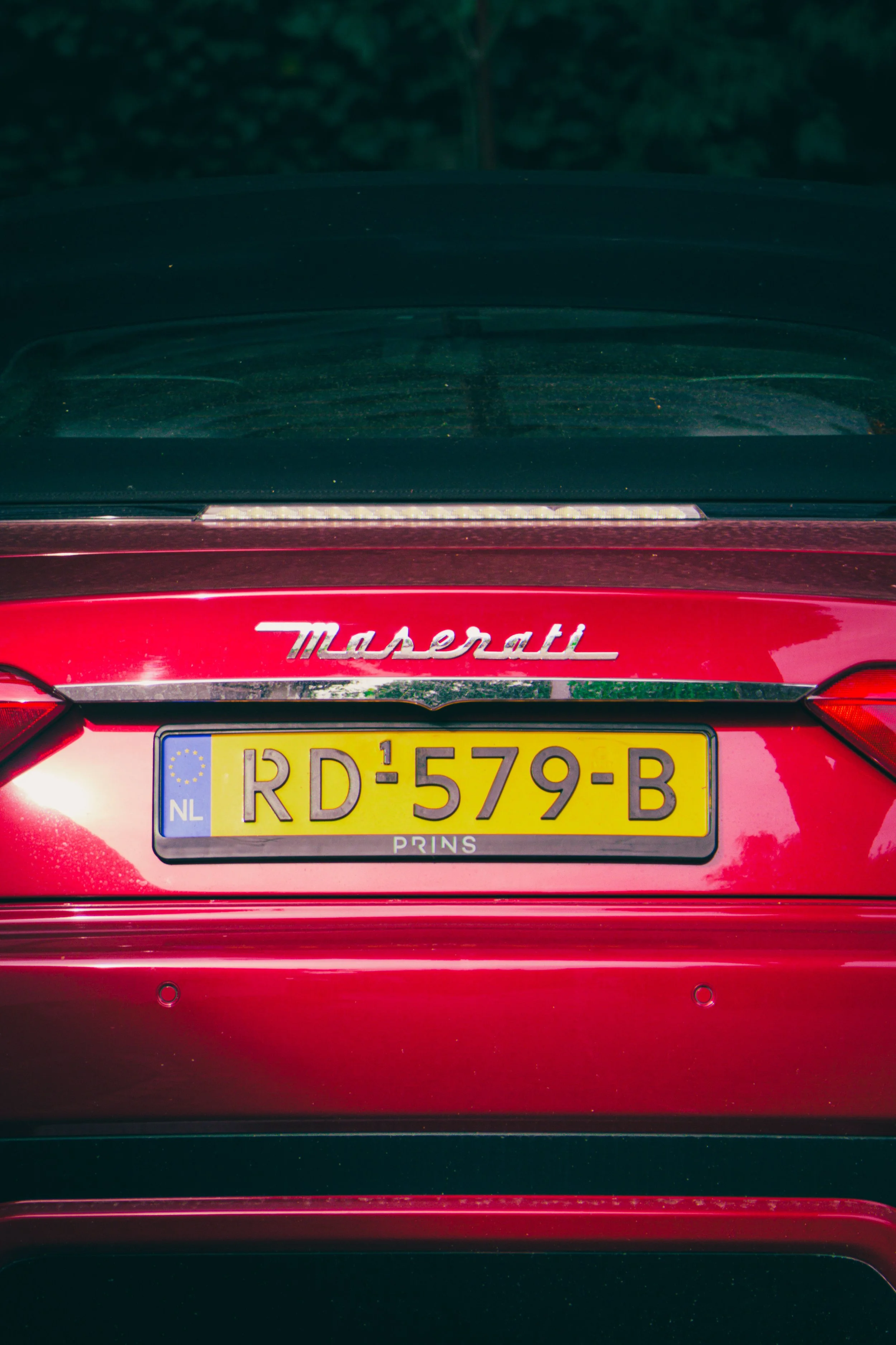Nahaufnahme des Hecks eines roten Maserati mit niederländischem Kennzeichen