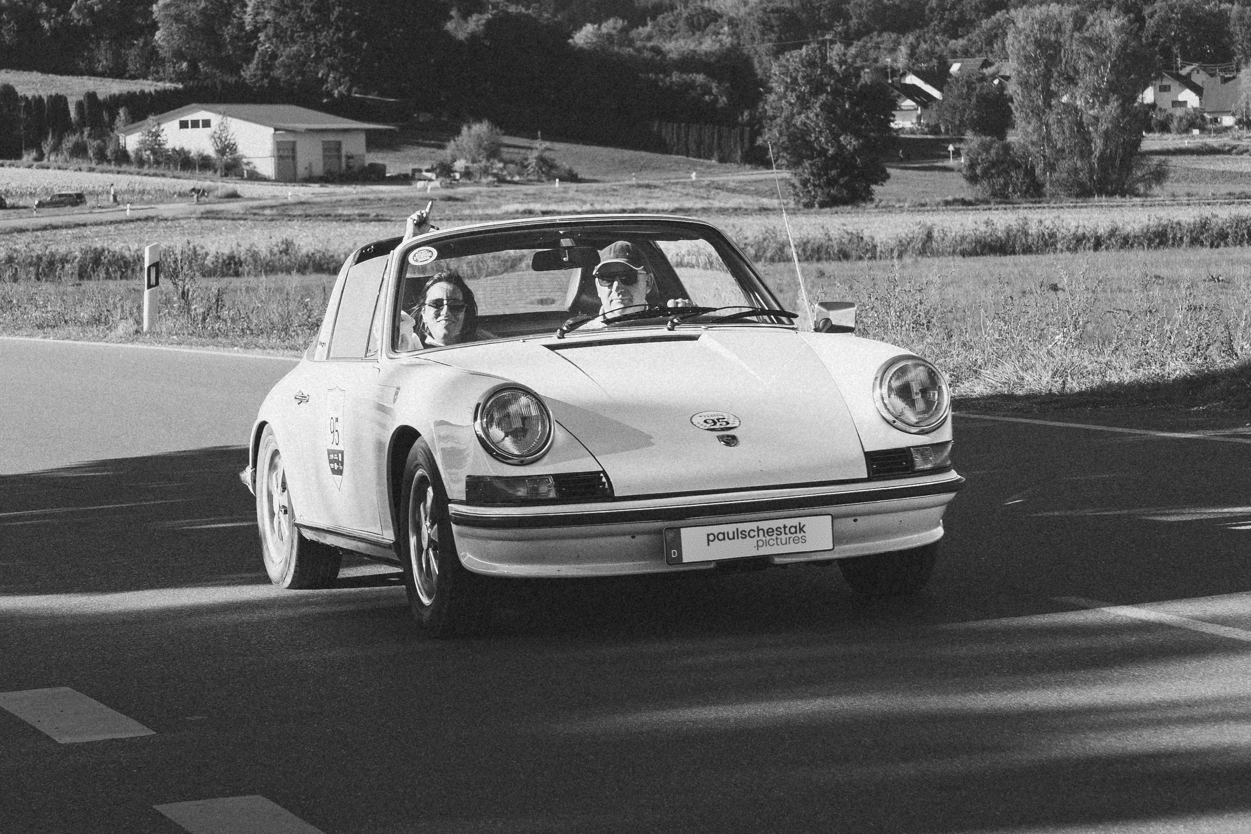 Schwarzweißaufnahme eines klassischen Porsche 911 auf der Rallye-Strecke