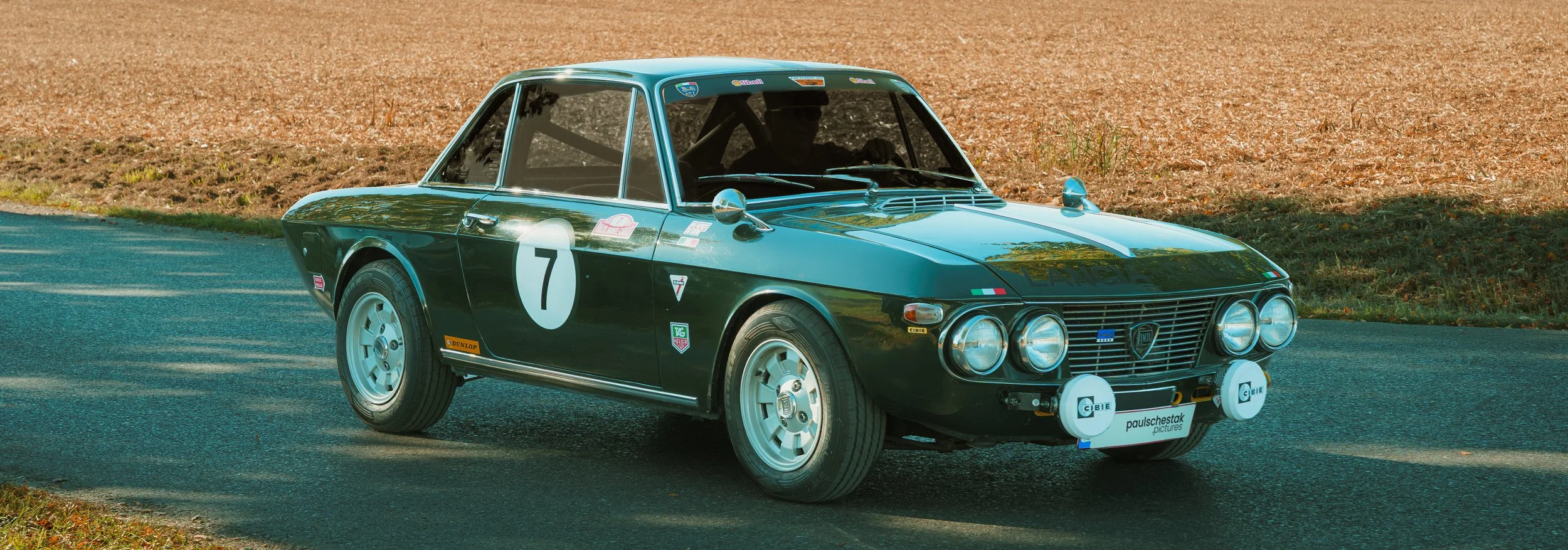 Dunkelgrüner Lancia Fulvia Coupé mit Startnummer 7 und Zusatzscheinwerfern