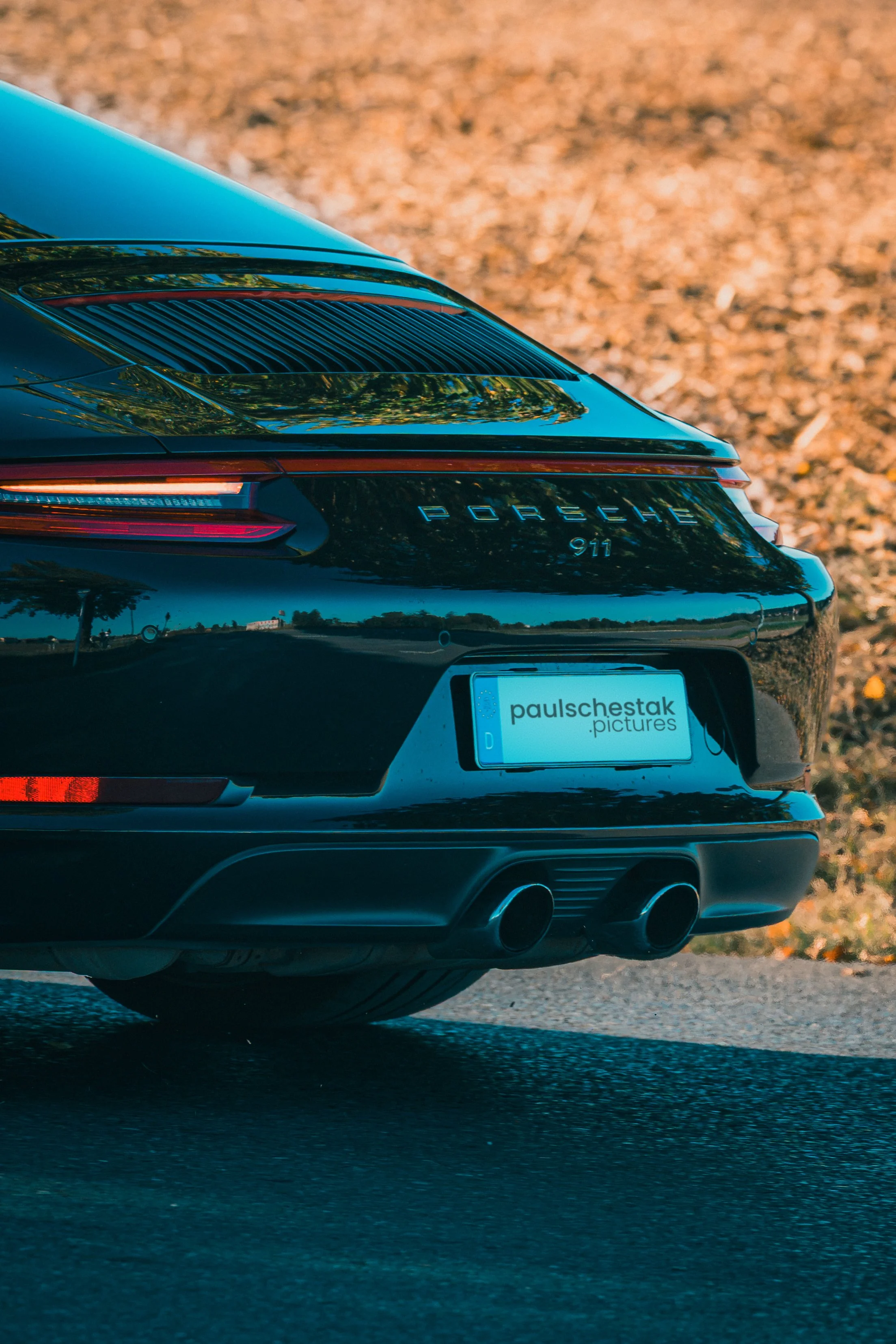 Heckpartie eines schwarzen Porsche 911 mit Schriftzug und Doppelendrohr