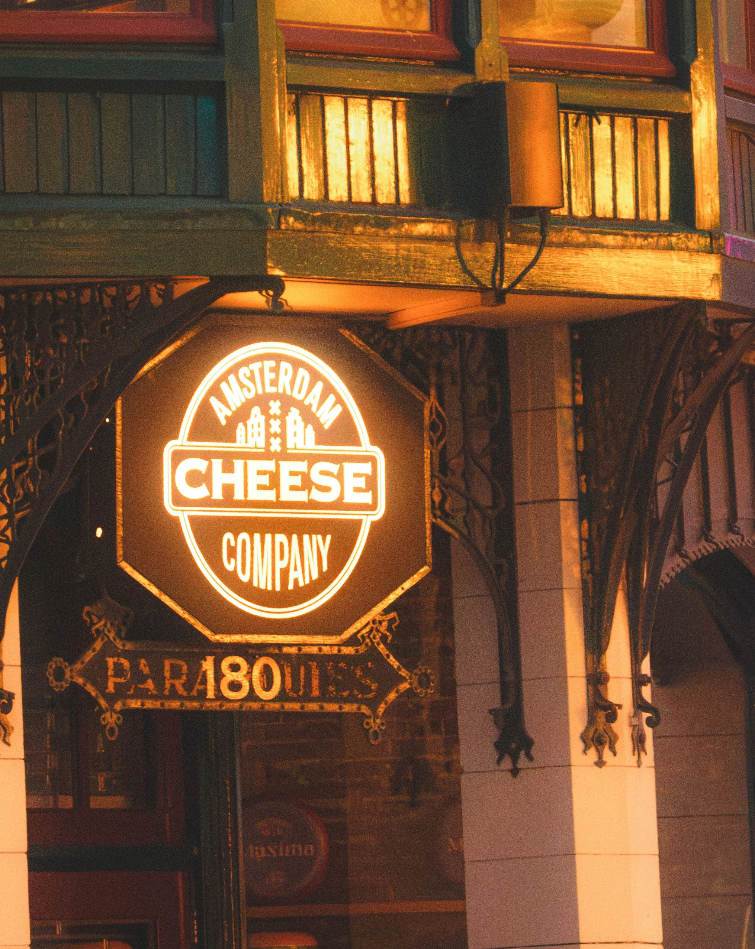 Beleuchtetes Vintage-Schild der "Cheese Company" an einer Gebäudeecke bei Nacht