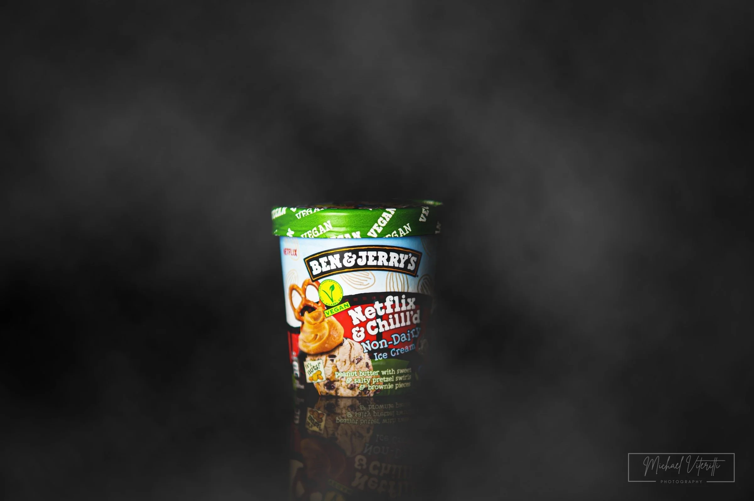 Cono di gelato vegano Ben & Jerry's Netflix & Chill'd, gusto burro di arachidi con pretzel salati, brownie e altra crema non lattiginosa, decorato con il coperchio verde con scritta vegano.