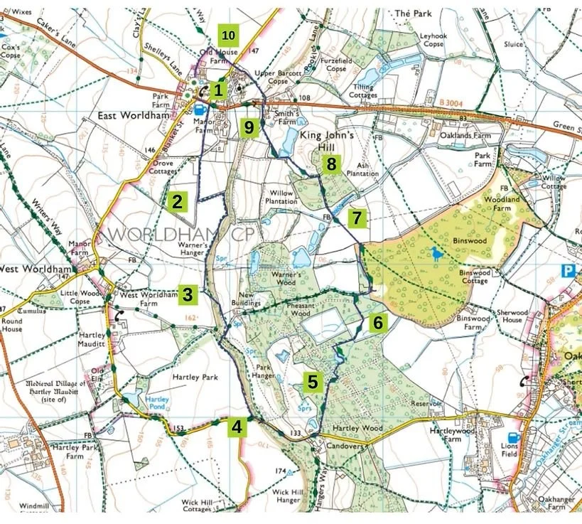 A detailed map of a rural area with numbered points indicating a walking or hiking trail. The map includes landmarks such as farms, woodlands, ponds, and roads, with some natural features like streams and a designated picnic area.