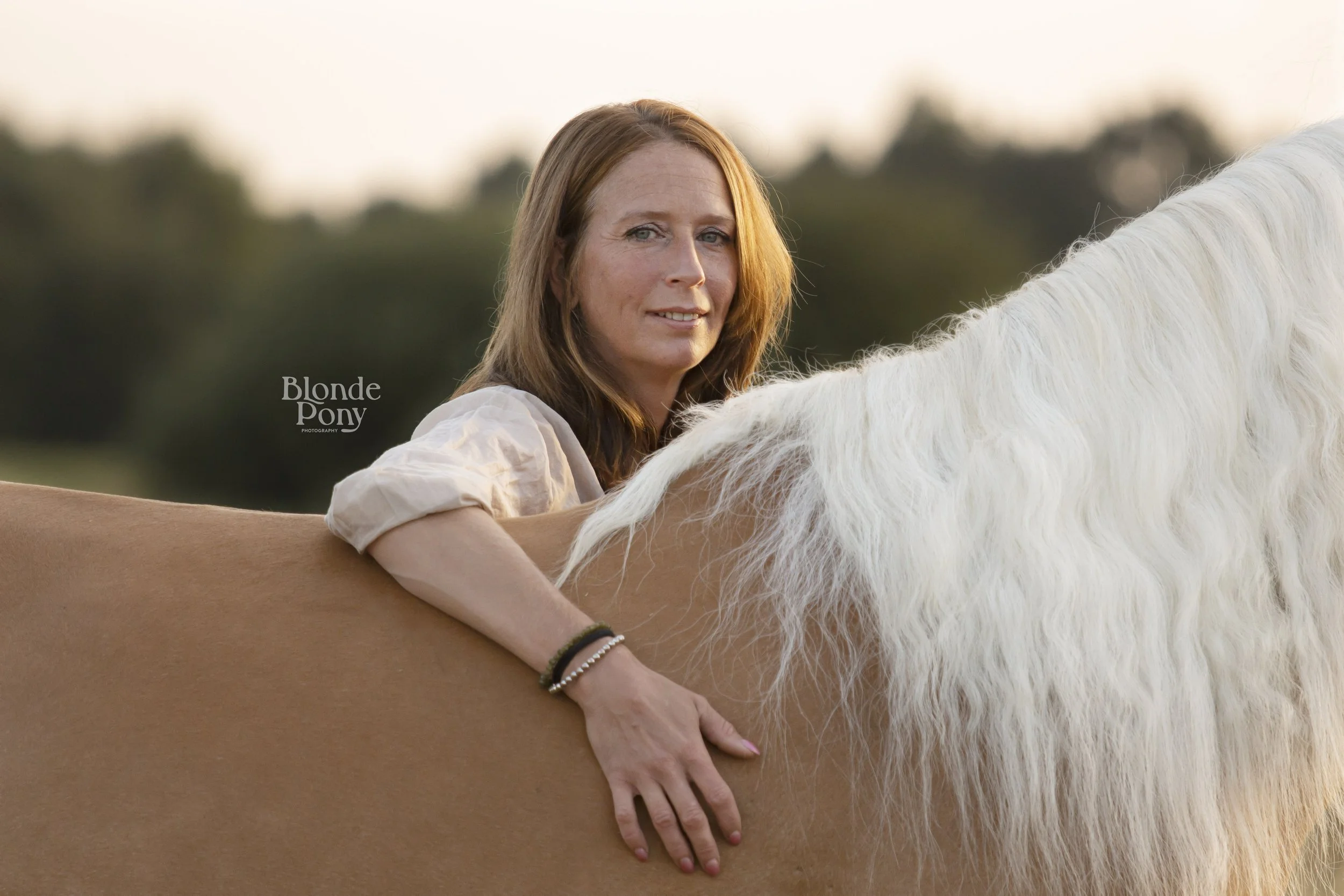 Vrouw knuffelt paard tijdens een buiten fotoshoot in de omgeving van Den Bosch