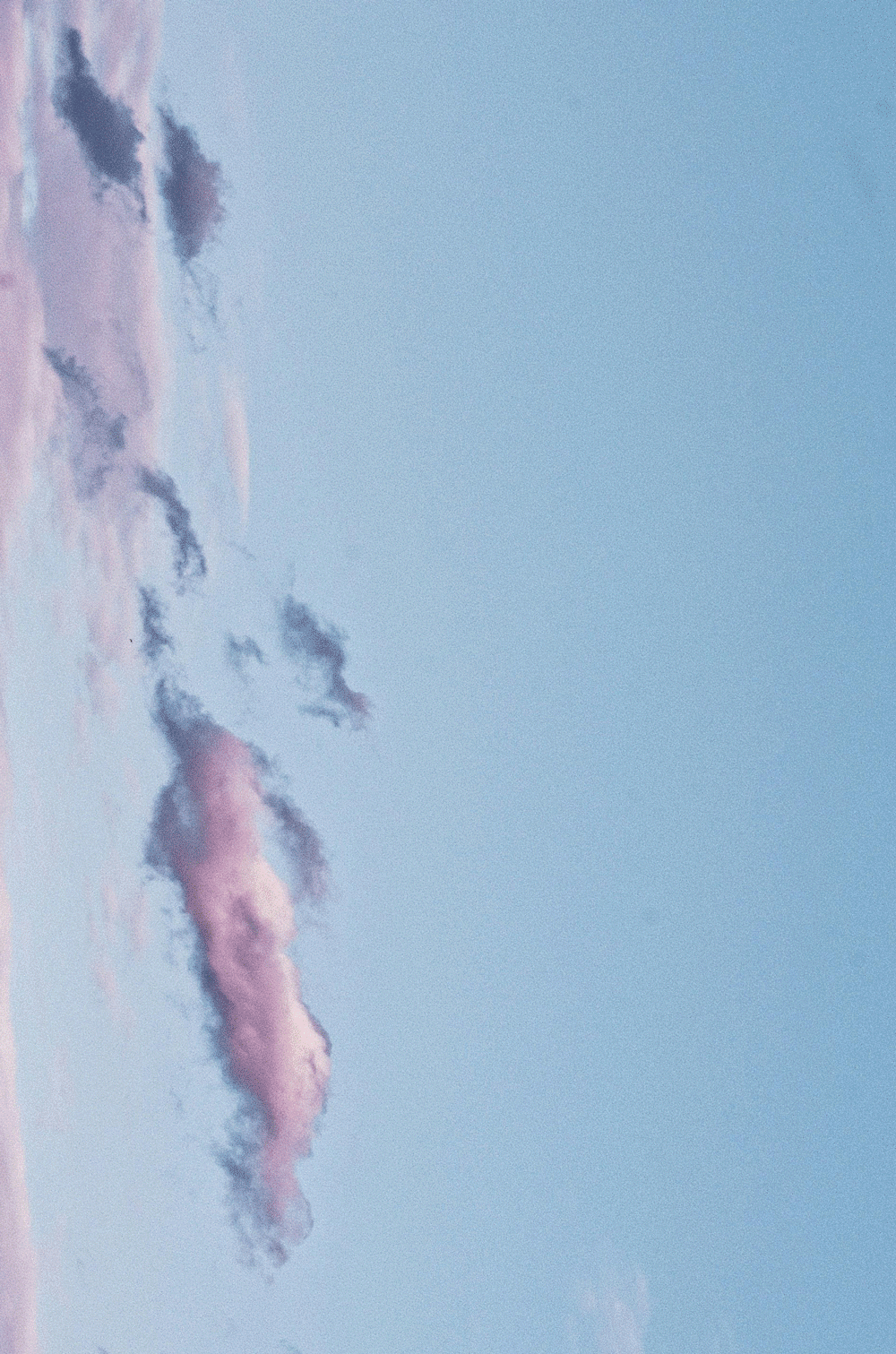 Pink and gray clouds in a blue sky.