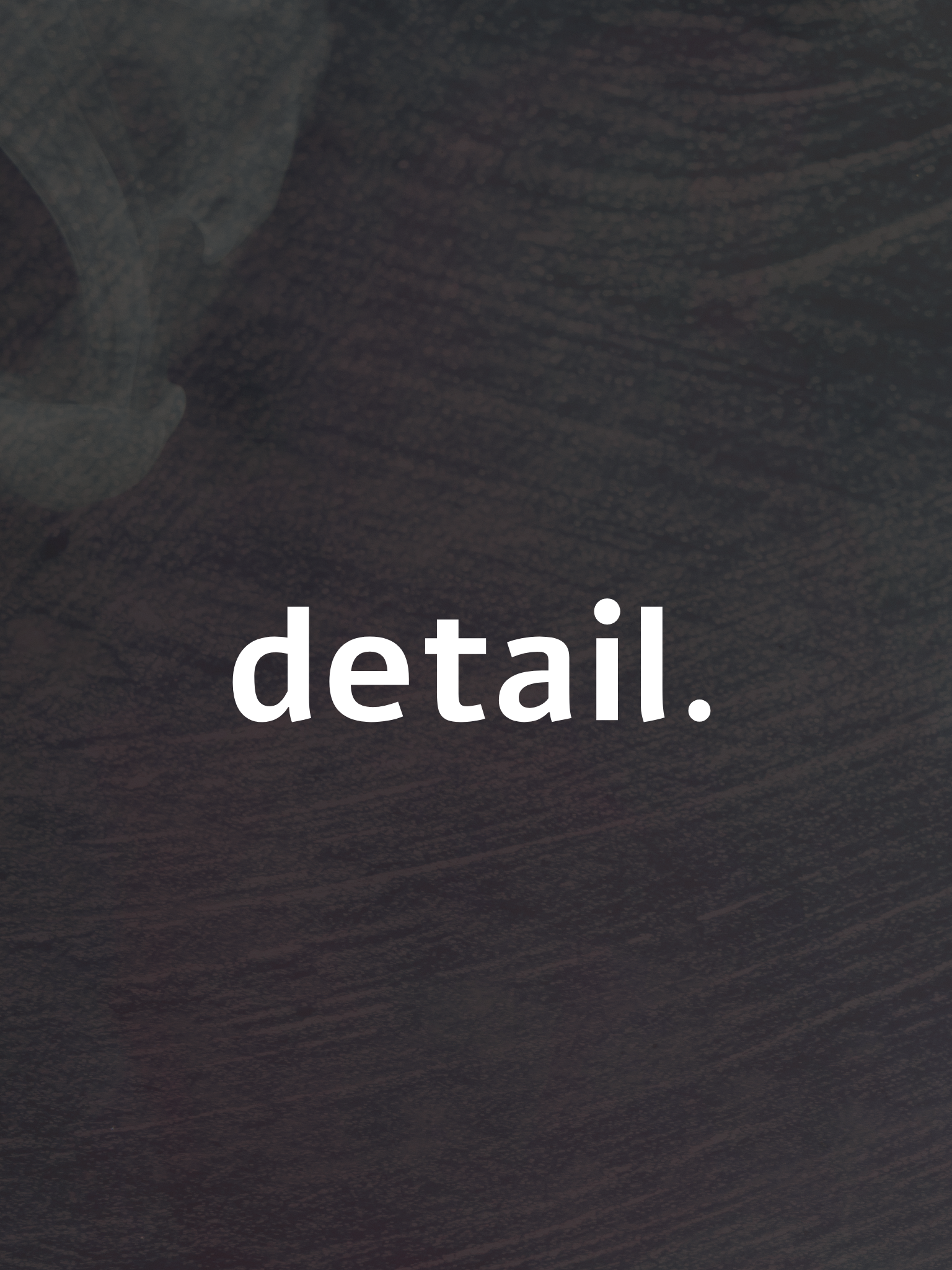 Close-up of a dark textured surface with white text that reads 'detail.'