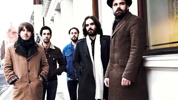 Five men standing outside a building.
