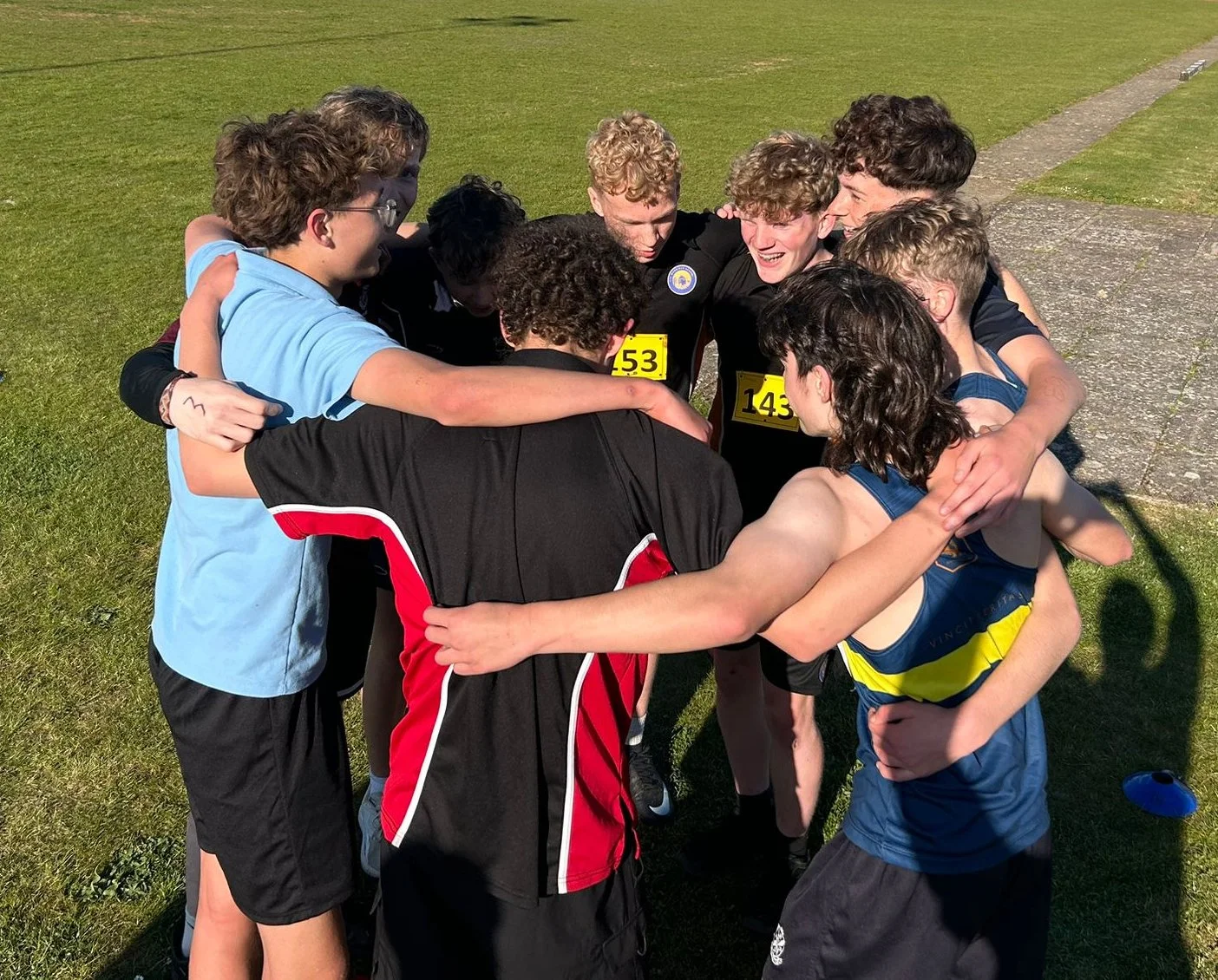 School rugby team gathered in a huddle during a match before returning to play