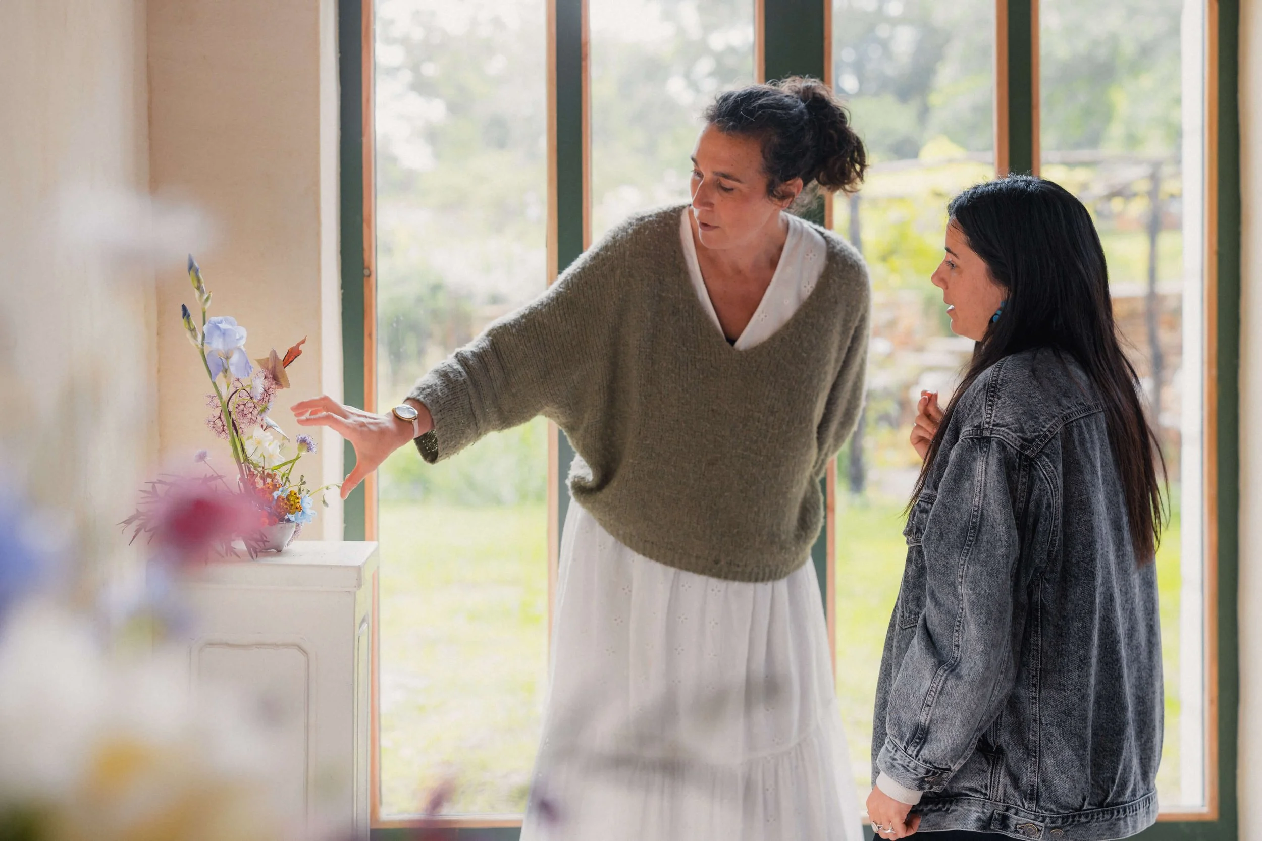 Accompagnement individuel autour d’une composition pendant une formation fleuriste immersive.