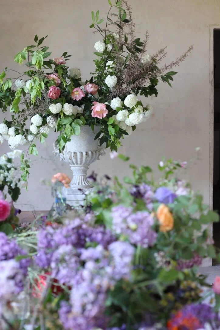 Grand bouquet dans un vase Médicis travaillé pendant l’Atelier Mariage.