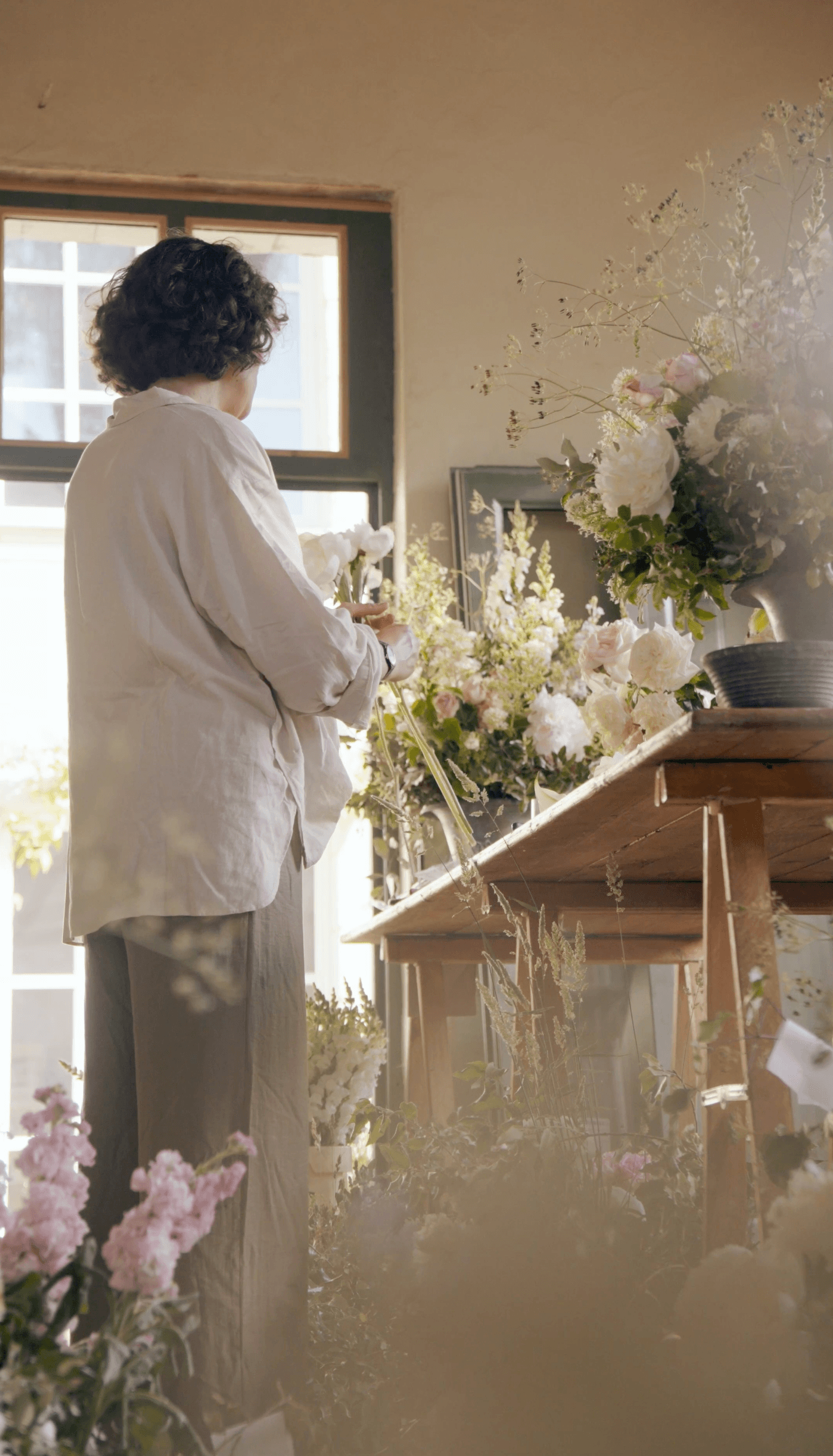 Chloé Le Berre en train de composer avec des fleurs françaises de saison à l’atelier.