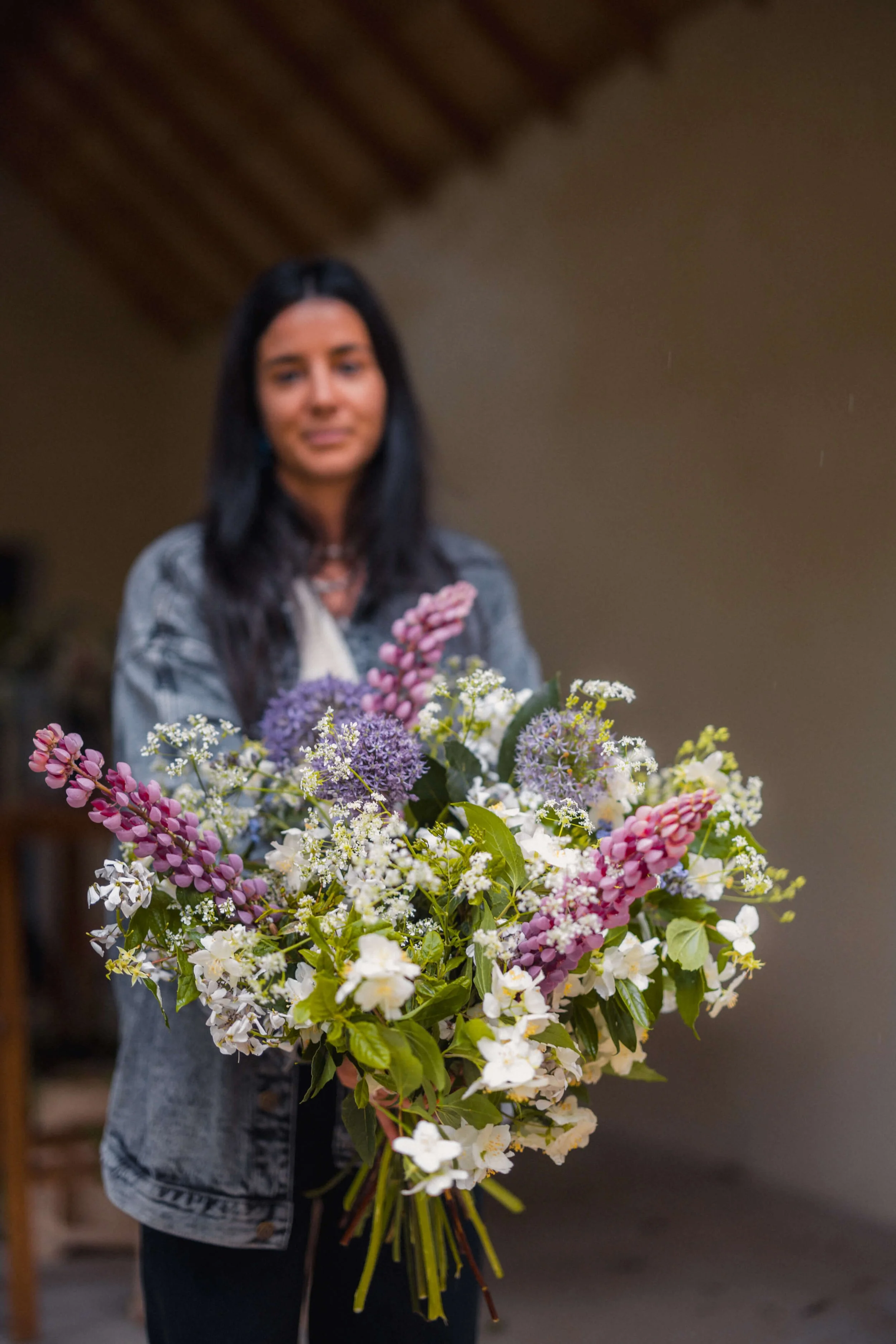 Participante tenant un bouquet réalisé pendant l’Atelier Devenir Fleuriste en Anjou.