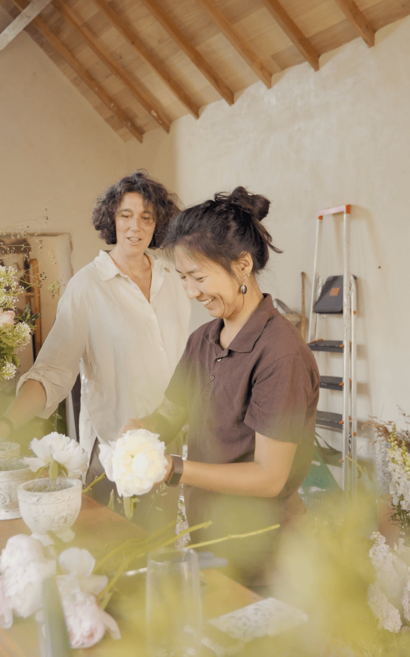 Chloé accompagne une participante pendant une formation floral design mariage.