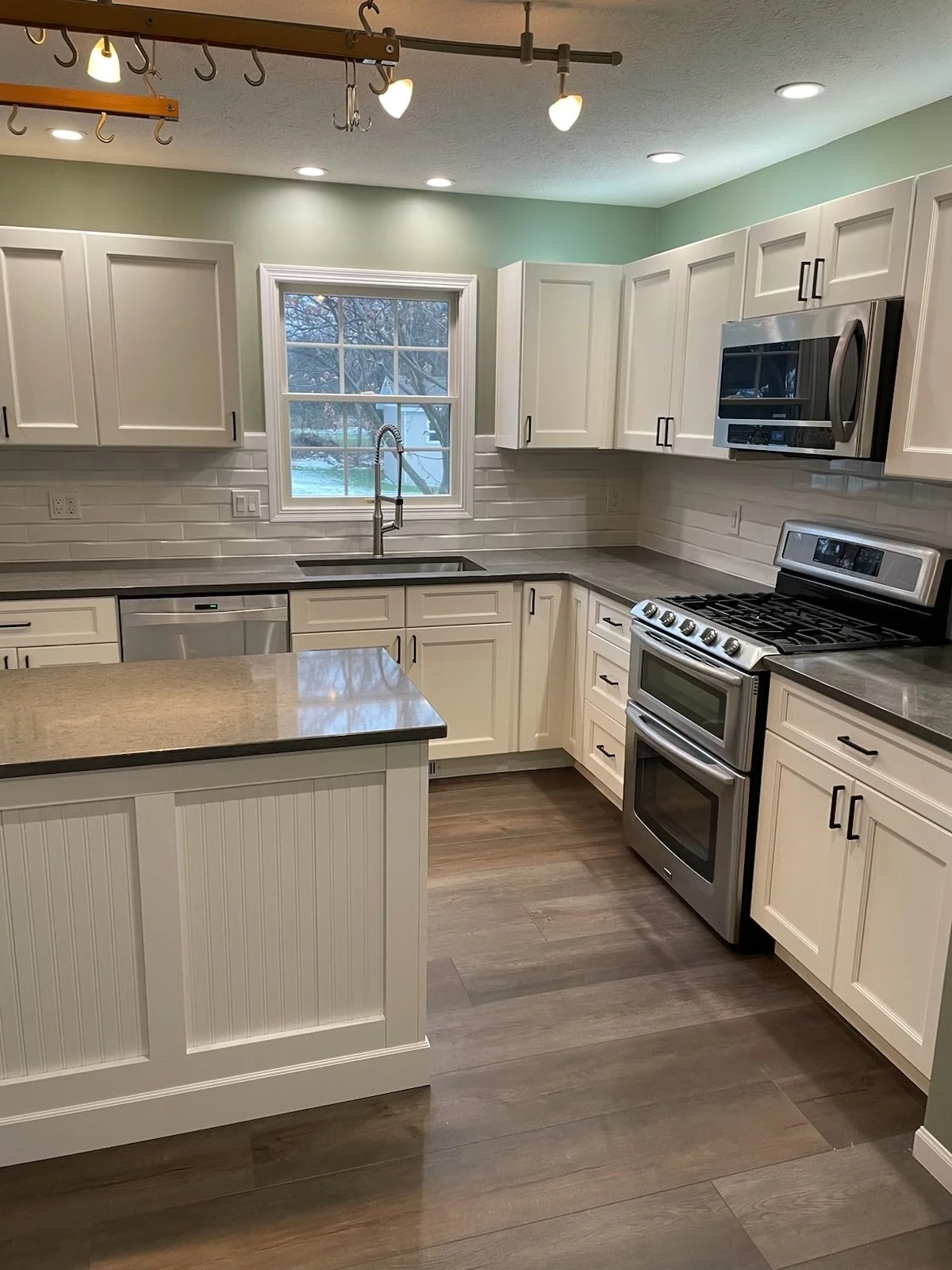 Modern kitchen remodel with white cabinets, subway tile backsplash, and island completed by Mr. H Remodel serving middle Tennessee.