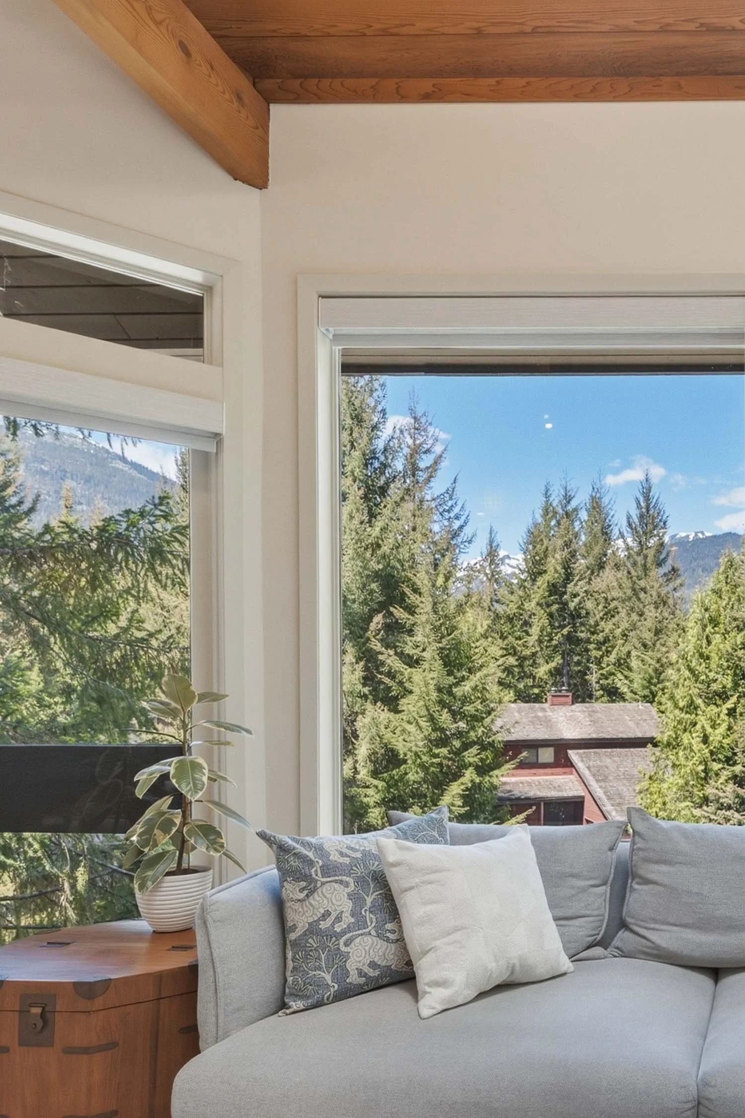 Open-concept living room at 6117 Eagle Drive featuring automated Hunter Douglas blinds, large scenic windows with alpine views, and a cozy layout near the Regency wood-burning fireplace.