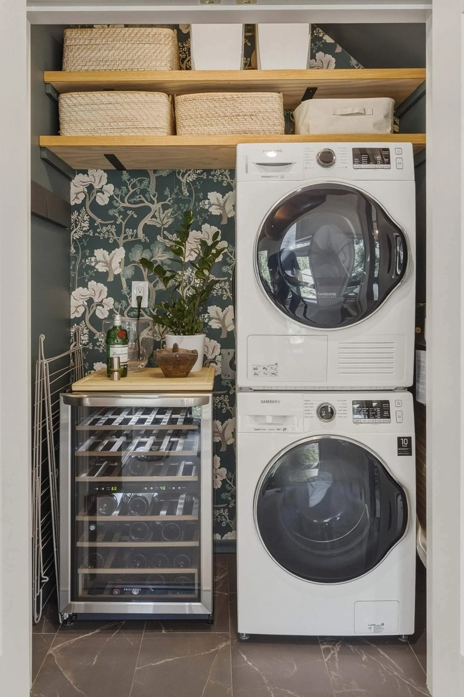 Dedicated laundry station inside 205-6117 Eagle Drive featuring a premium stacked Samsung washer and dryer set, custom wood storage shelves, and an integrated beverage wine cooler.