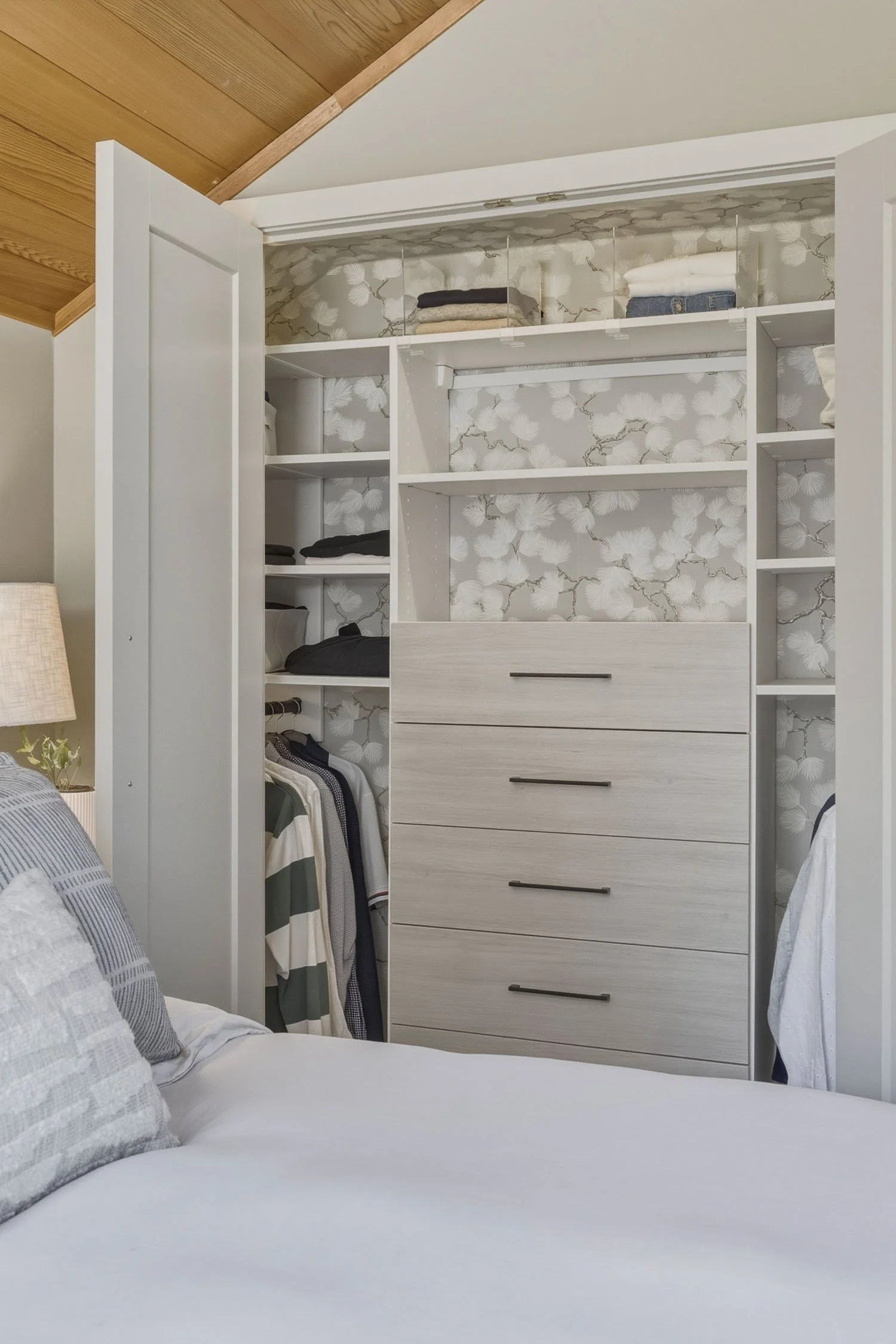 Bright primary bedroom layout within this Whistler 2-bedroom townhouse for sale, styled with a vaulted wood ceiling, custom built-in wardrobe storage, and large windows.