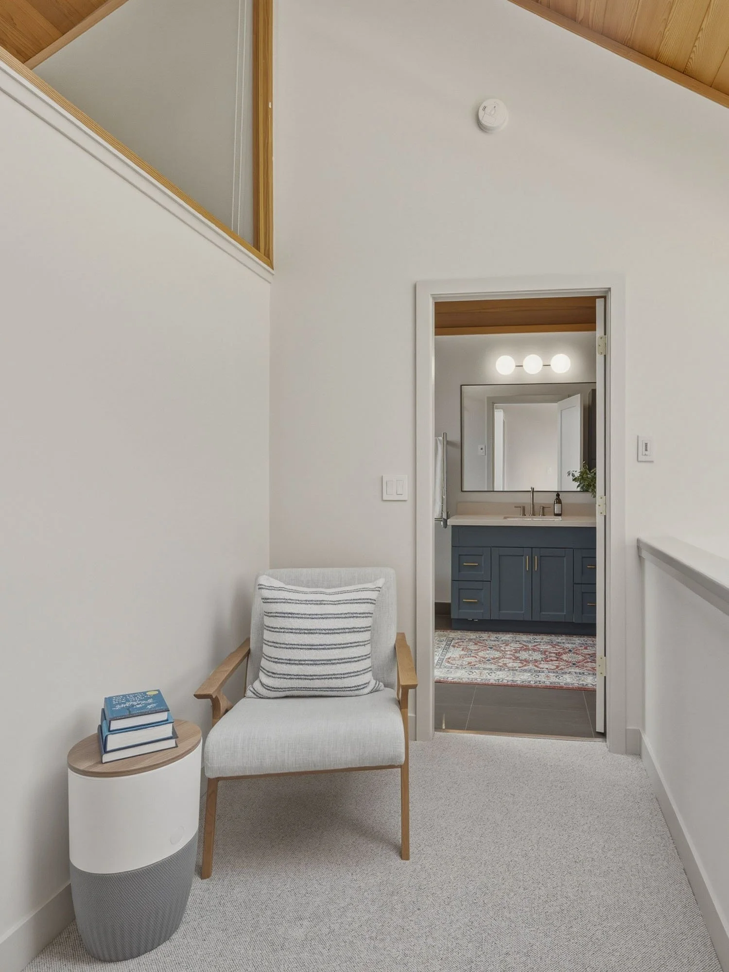 The upper-level flex den landing layout at 205-6117 Eagle Drive, showcasing a bright reading nook beneath a vaulted wood ceiling, located just outside the primary bedroom and master bathroom.