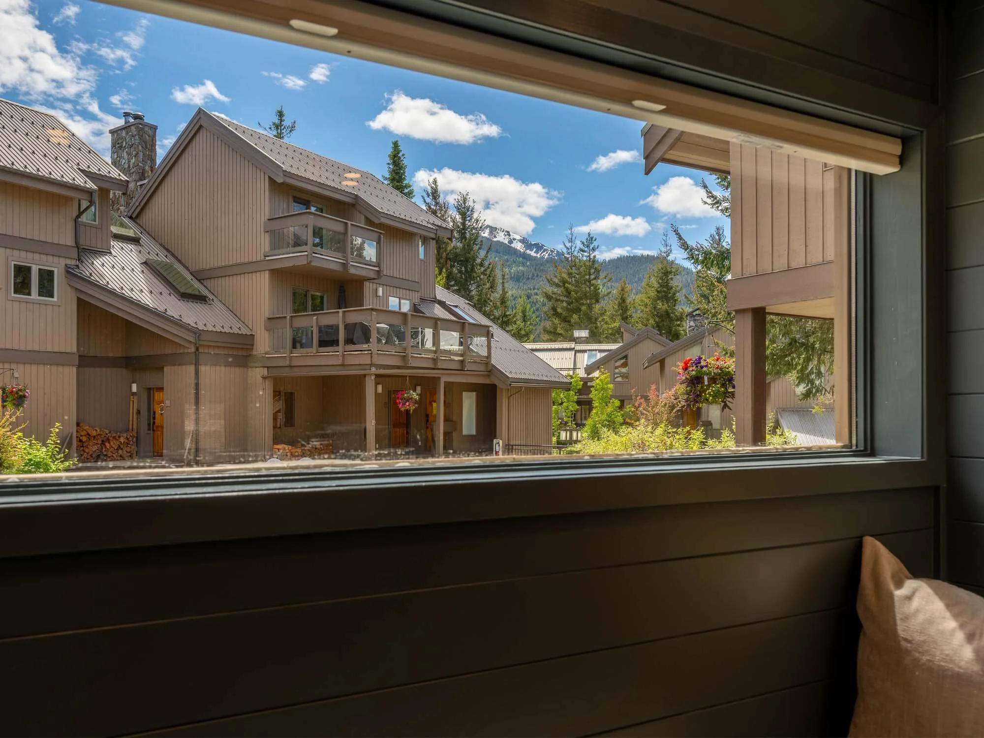 Stunning, unobstructed alpine views of the surrounding forest and snow-capped peaks seen through the windows of this Whistler Cay Heights townhouse for sale.