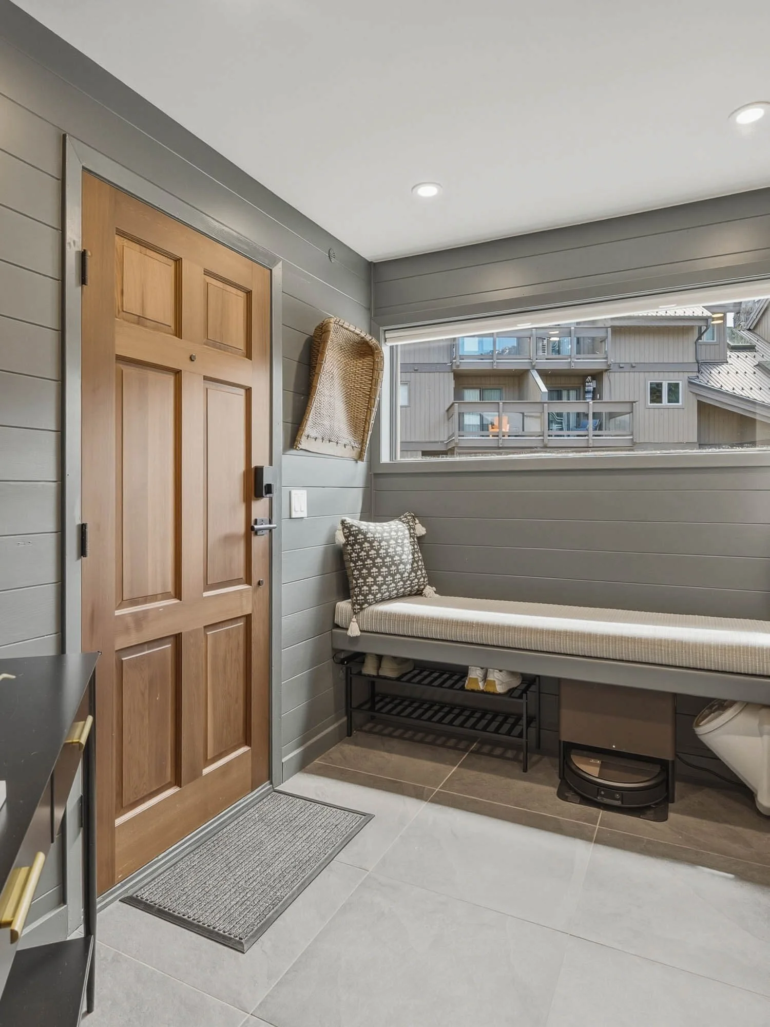 Functional mountain mudroom and entry landing at 205-6117 Eagle Drive featuring a built-in window bench seat, durable tile flooring, and streamlined gear storage solutions.