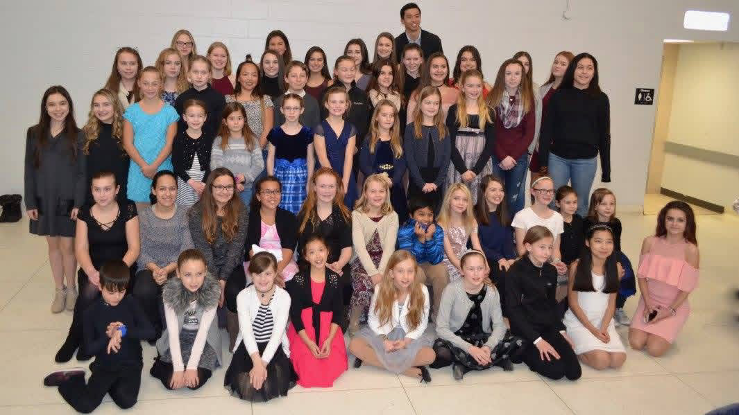 Group of children and adults posing indoors for a photo