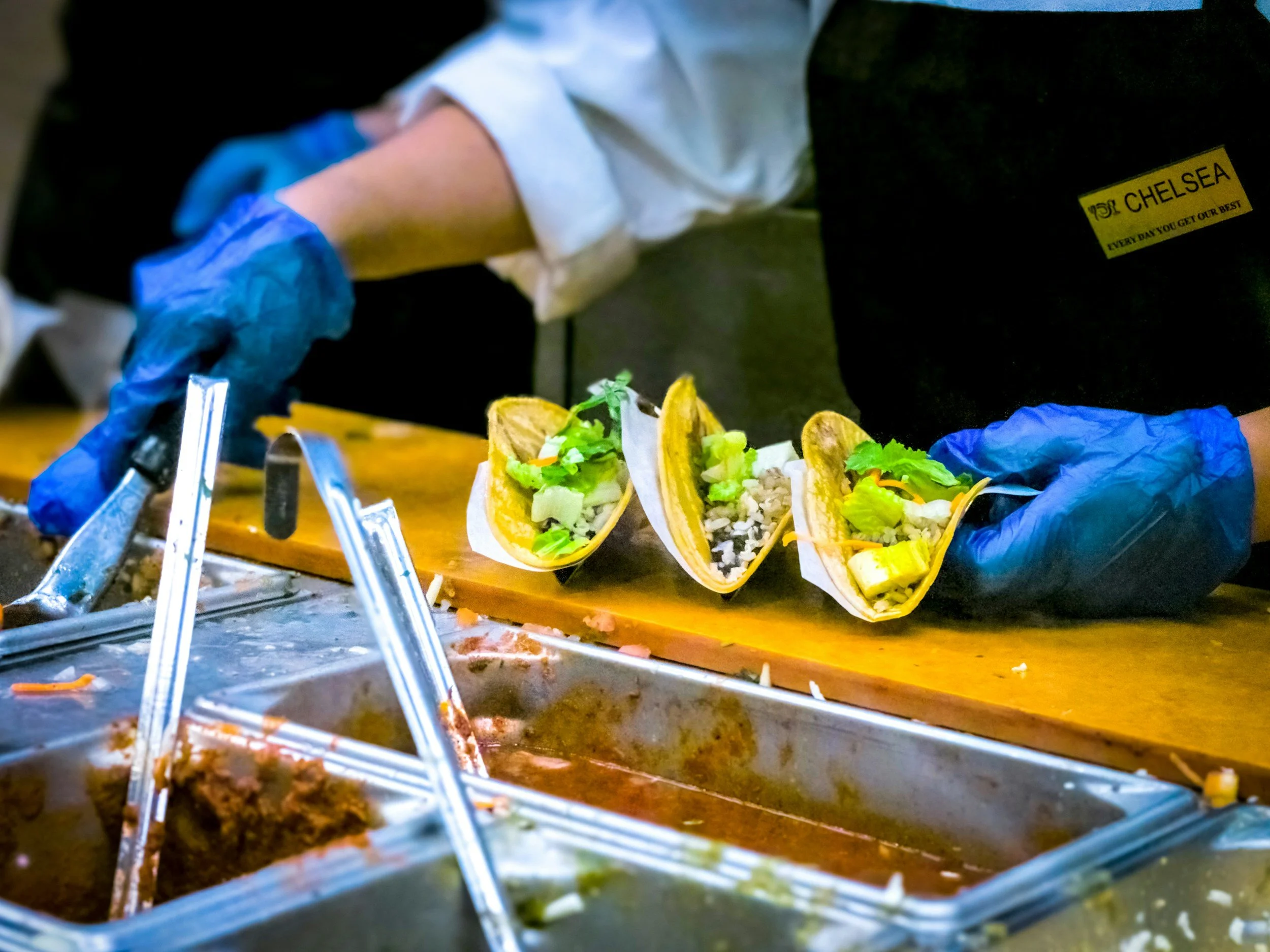 Concession crew preparing and serving food behind a venue counter during an event.