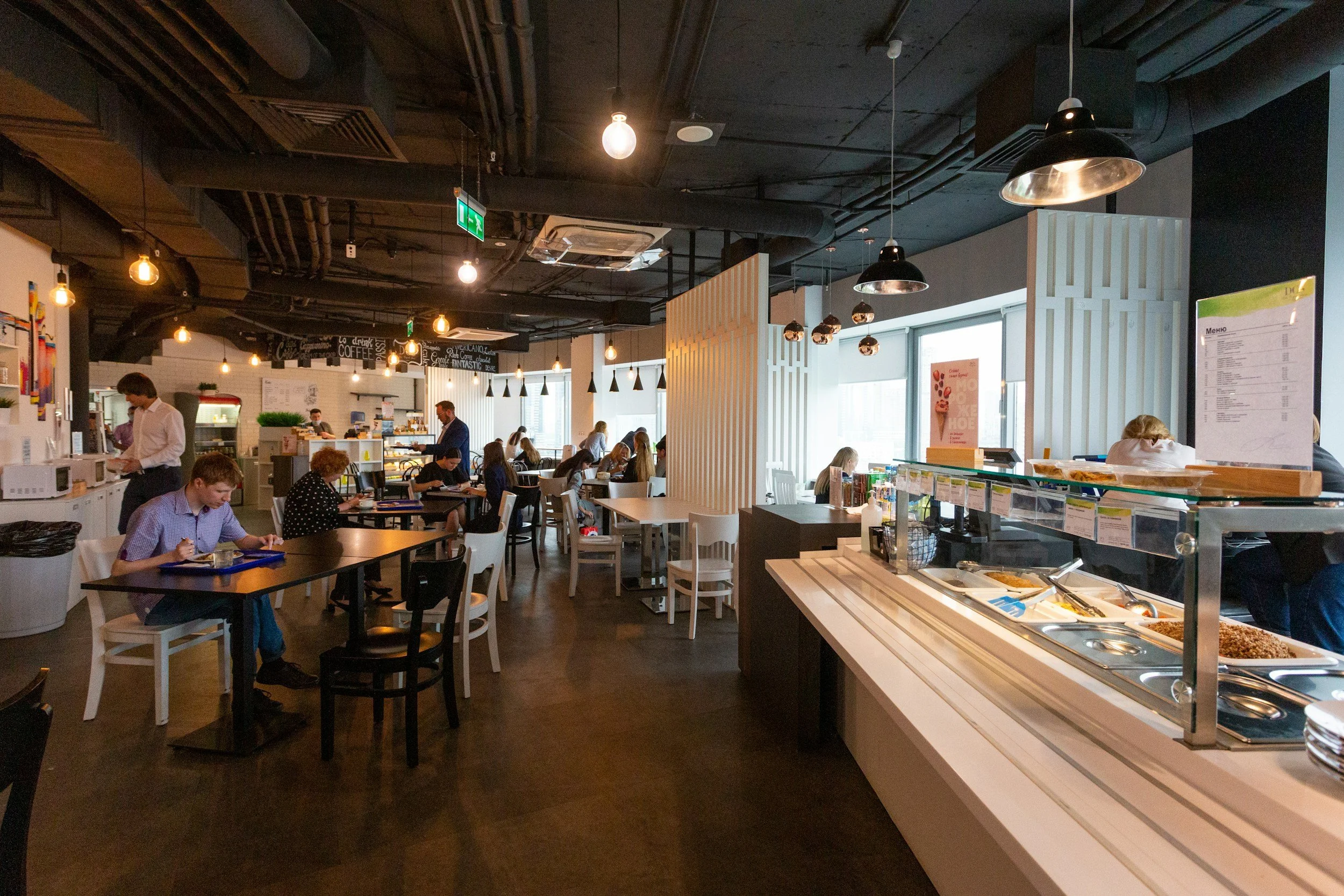 People gathered in a busy university dining hall at lunch.
