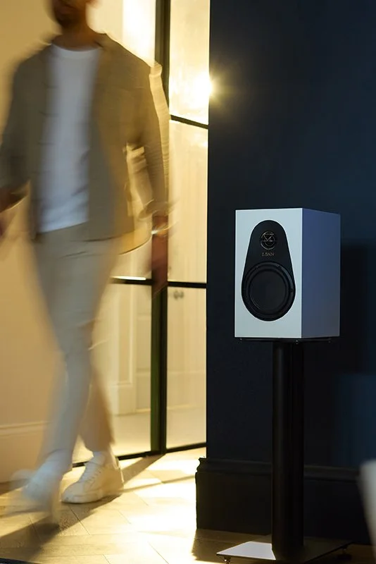 Persona in movimento accanto a un diffusore Linn posizionato su un supporto