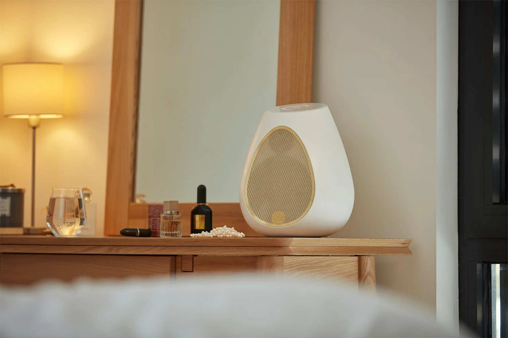 Diffusore wireless Linn Series 3 con griglia dorata, collocato su una consolle in legno all’interno di una camera luminosa.