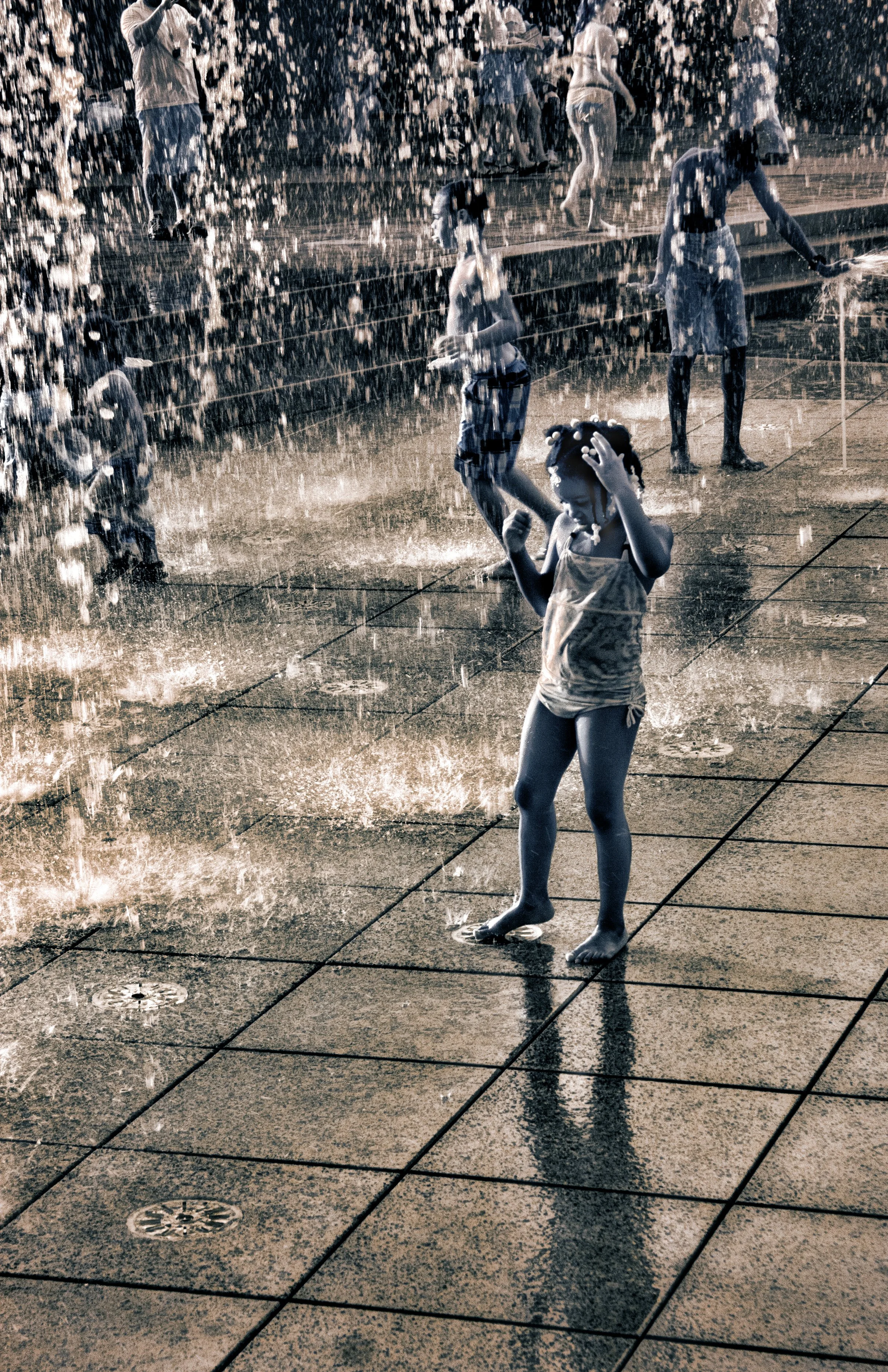 Infrared- "All Wet, Savannah" GA. Children playing in splash pad water spurts.  Sepia.