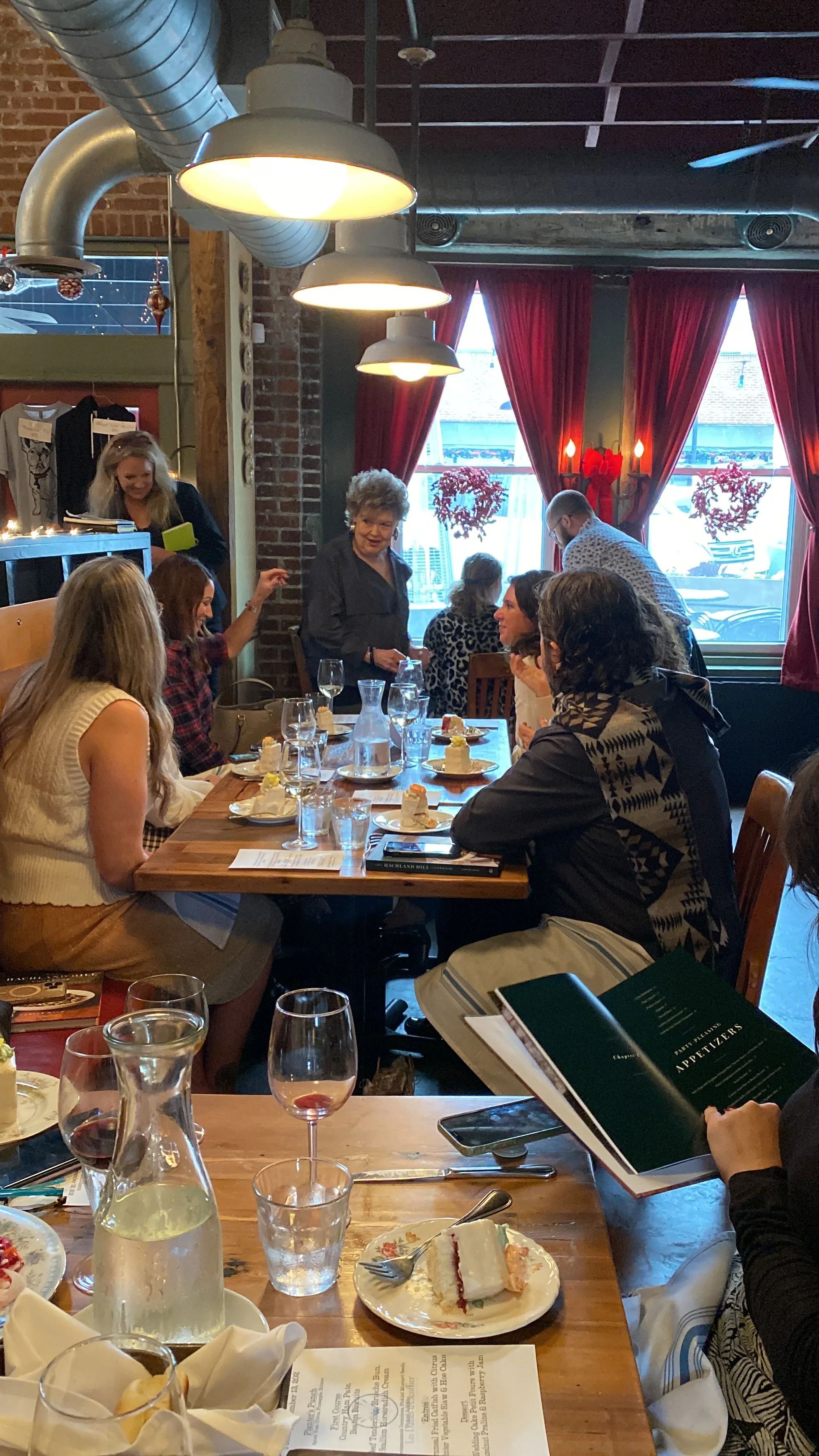  Women having lunch while chef Deb Paquette addresses the room at a Les Dames Nashville lunch event at Cafe Margot in Nashville, TN 