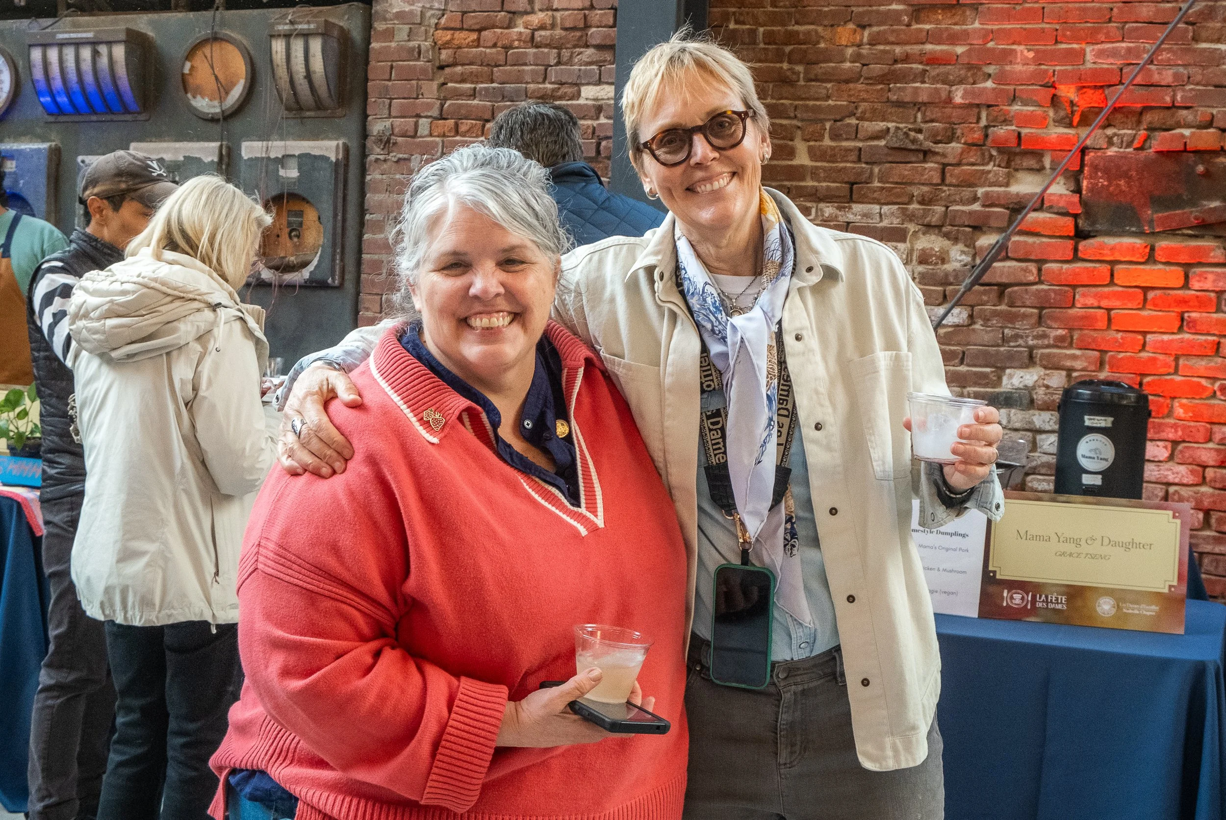  Two women smiling at the camera while at the event “La Fete De Dames” a fundraiser event organized by Les Dames Nashville 