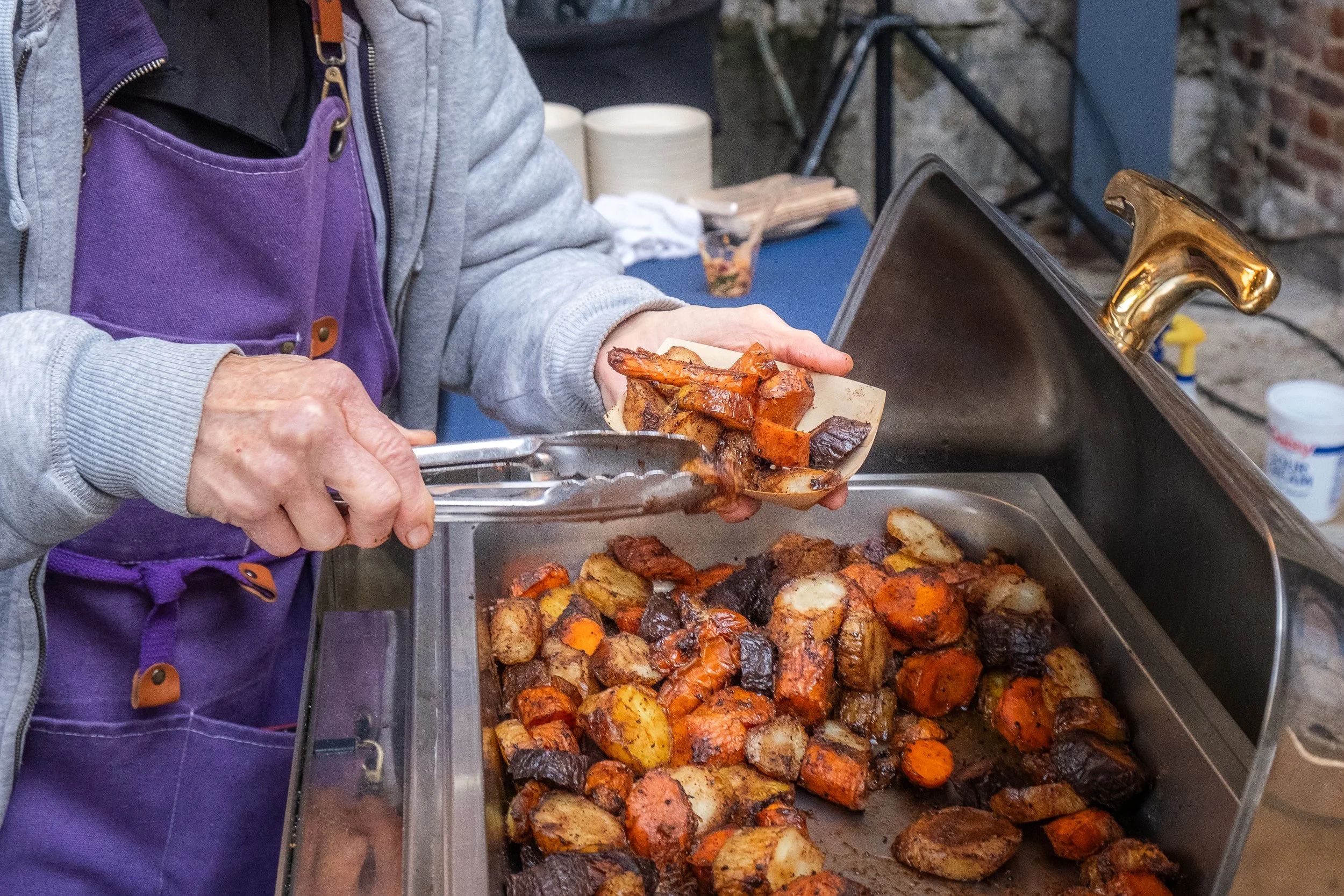 Someone serving food to patrons at “La Fete De Dames” a fundraiser event organized by Les Dames Nashville 